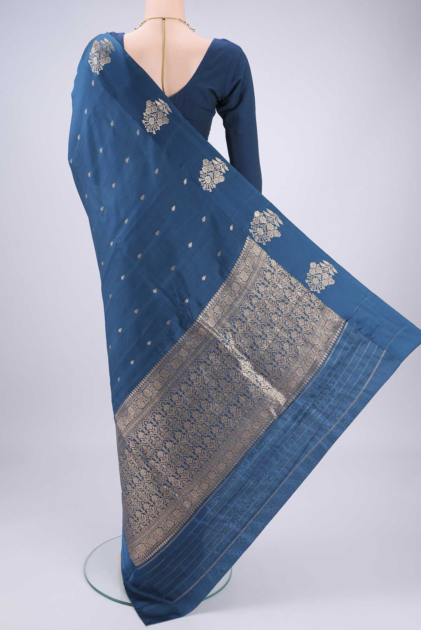 Flat view of Blue Banarasi Katan Silk Saree with Zari Butta on the body and Zari Border. 