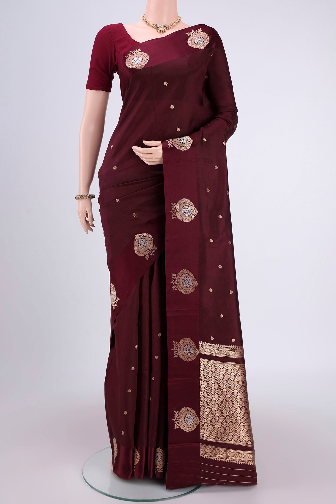 Coffee Brown Banarasi Katan Silk Saree with Zari Butta on the body and Zari Border.  displayed on a mannequin