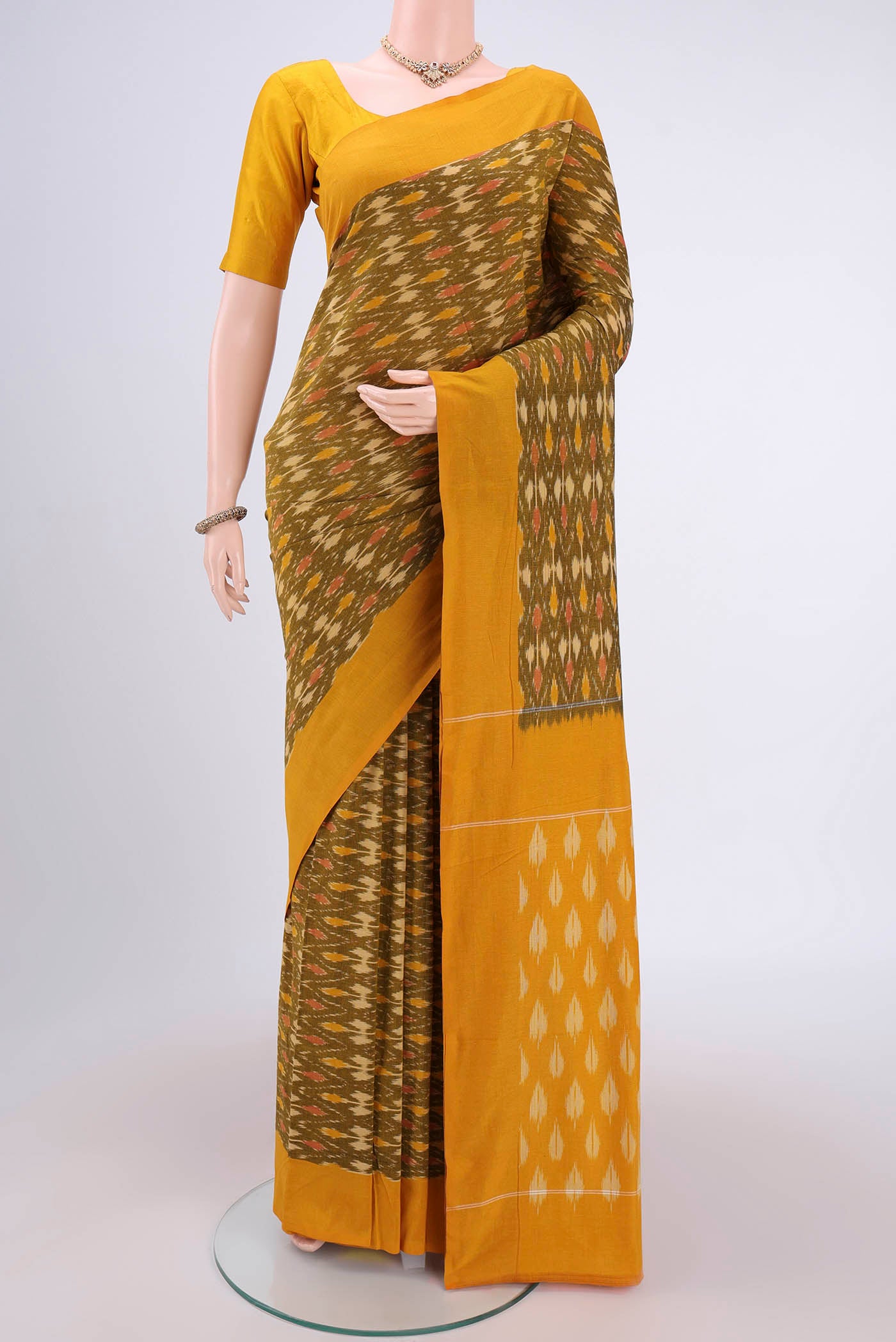 Mehandi Green Pochampally Cotton Saree with Ikat design on the body and Ikat Border.  displayed on a mannequin