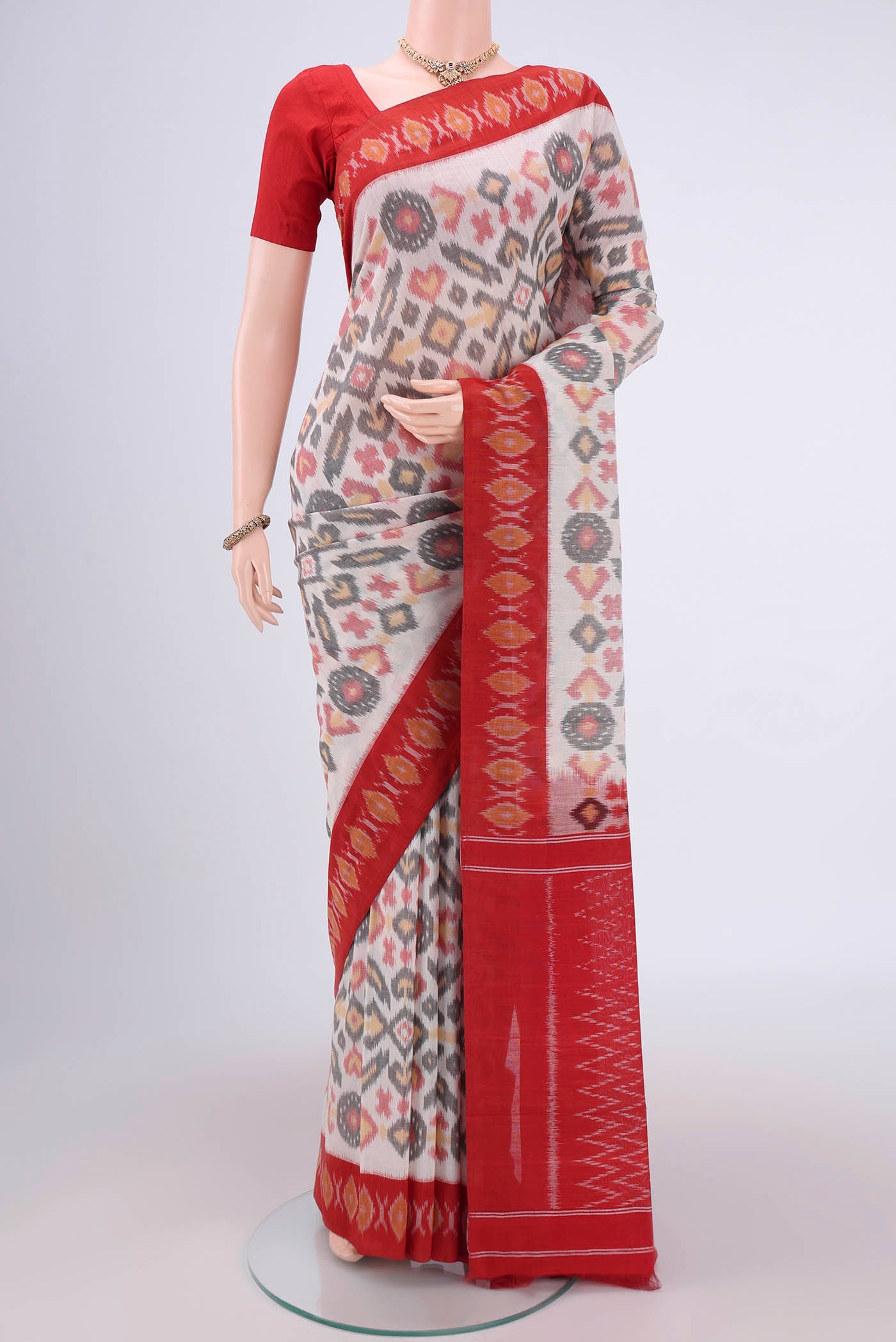 White Pochampally Cotton Saree with Ikat design on the body and Ikat Border.  displayed on a mannequin