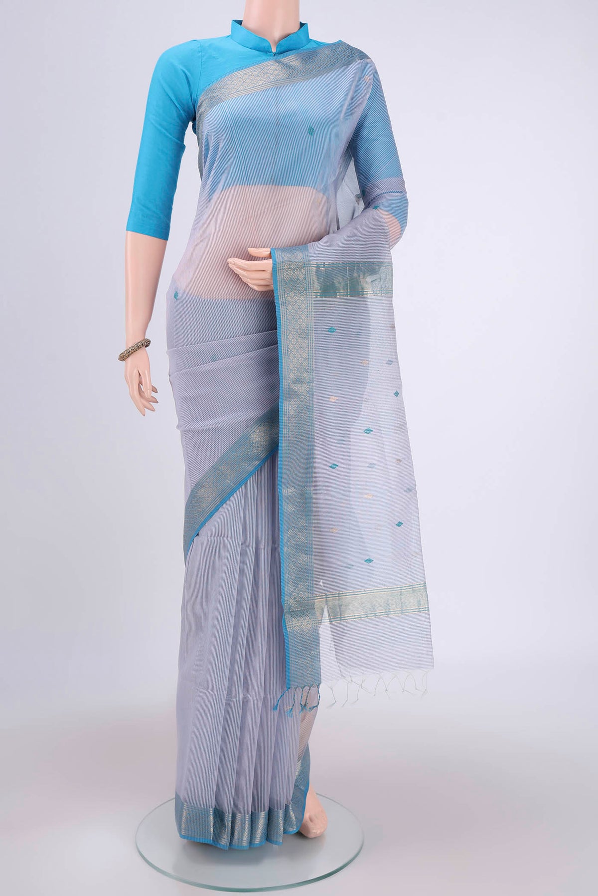 Lilac Maheshwari Silk Cotton Saree with Zari And Thread Butta on the body and Zari Border.  displayed on a mannequin