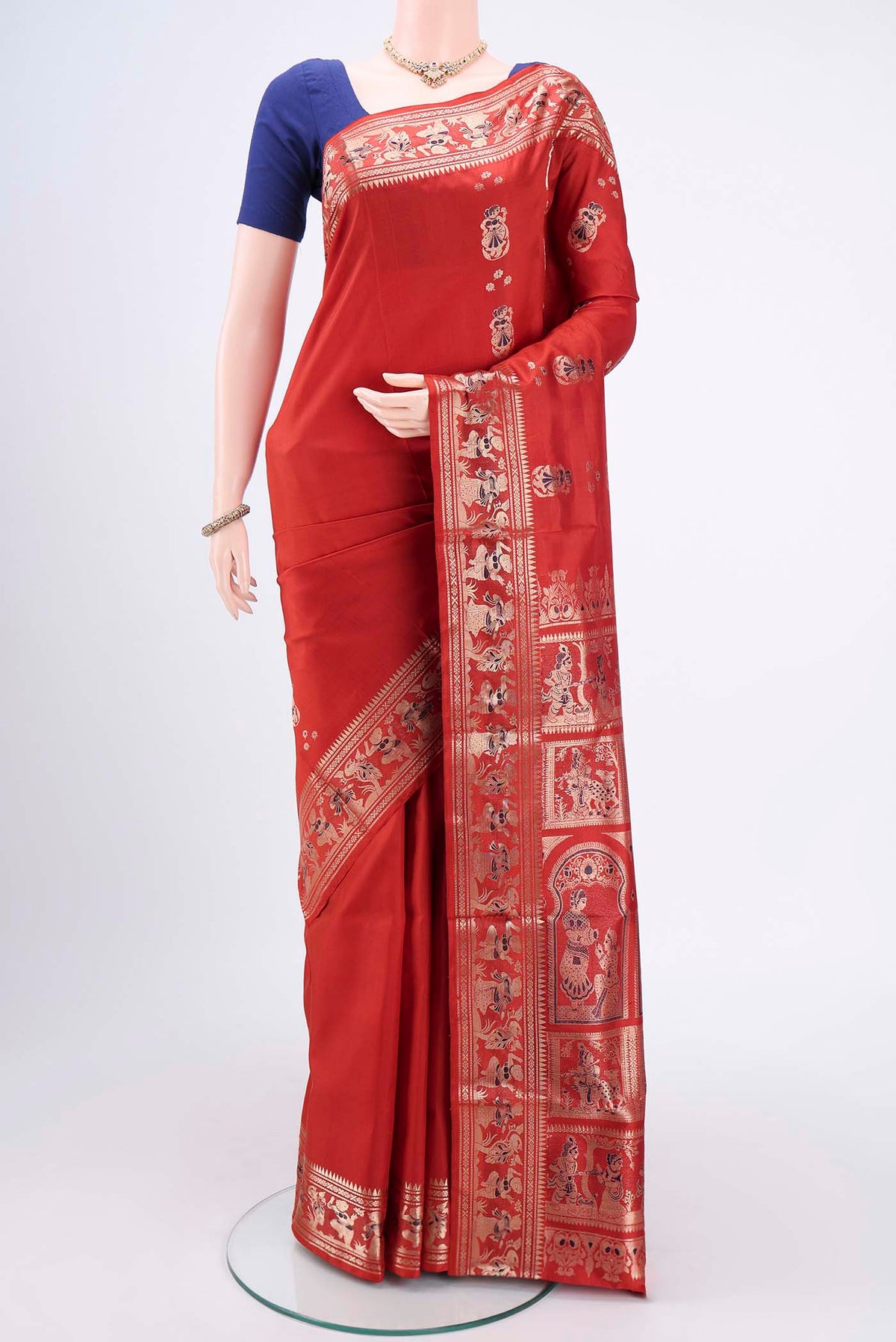 Rust Baluchari Silk Saree with Zari And Thread Butta on the body and Zari And Thread Border.  displayed on a mannequin