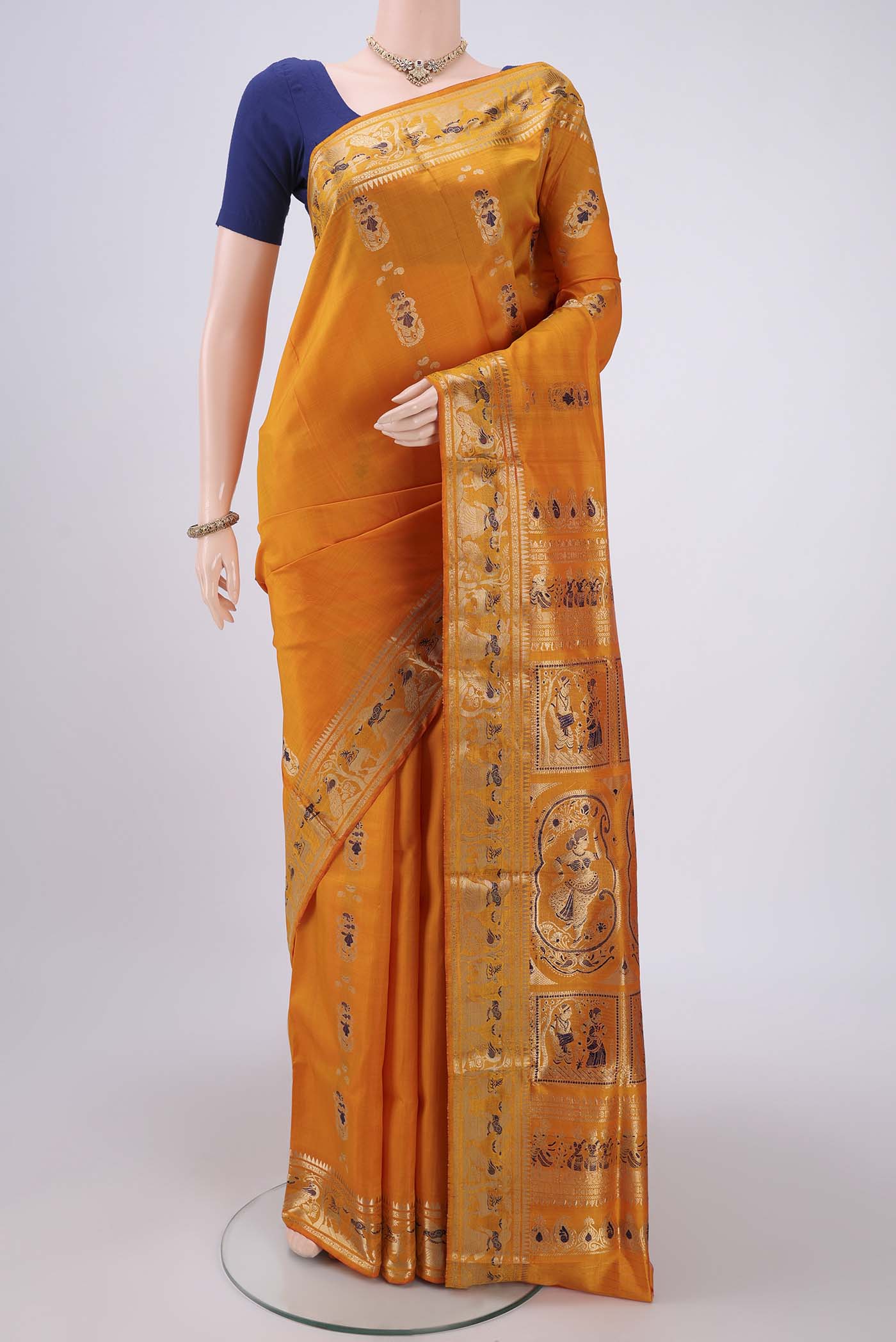 Orange Baluchari Silk Saree with Zari And Thread Butta on the body and Zari And Thread Border.  displayed on a mannequin
