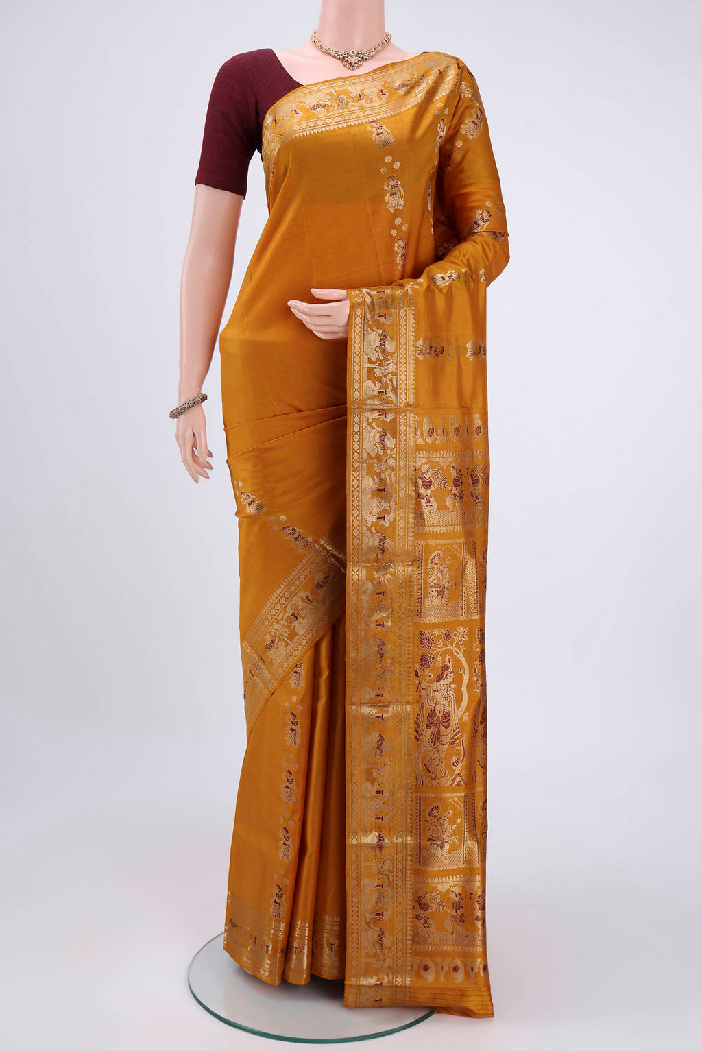 Mustard Baluchari Silk Saree with Zari And Thread Butta on the body and Zari And Thread Border.  displayed on a mannequin
