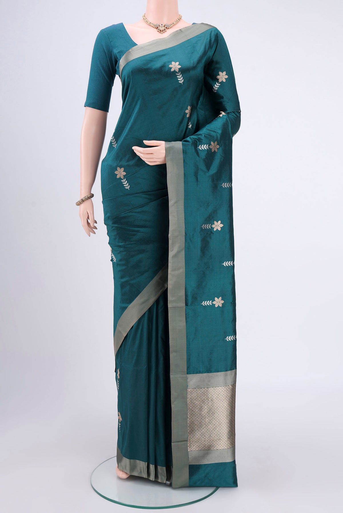 Turquoise Banarasi Silk Saree with Zari Butta on the body and Zari Border.  displayed on a mannequin