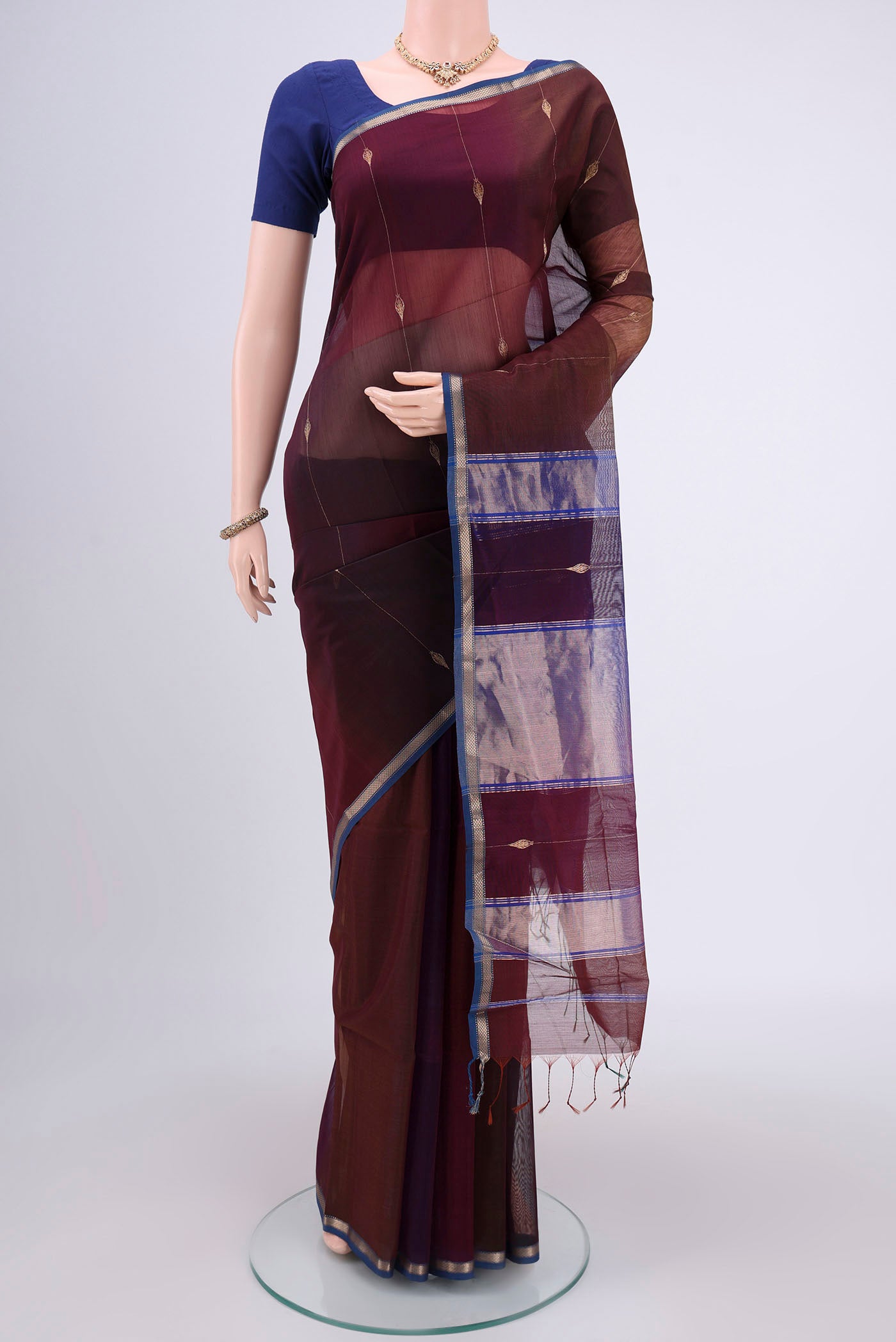 Brown Maheshwari Silk Cotton Saree with Zari And Thread Butta on the body and Zari Border.  displayed on a mannequin