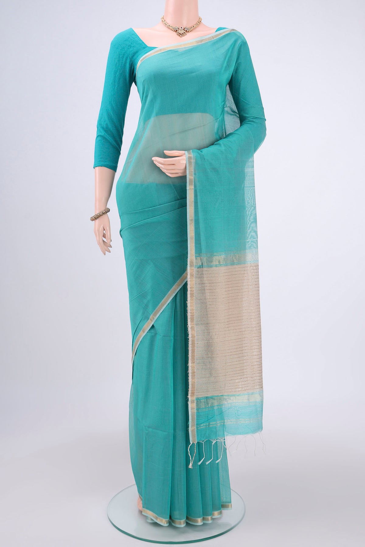 Sky Blue Maheshwari Silk Cotton Saree with Zari And Thread Butta on the body and Zari Border.  displayed on a mannequin