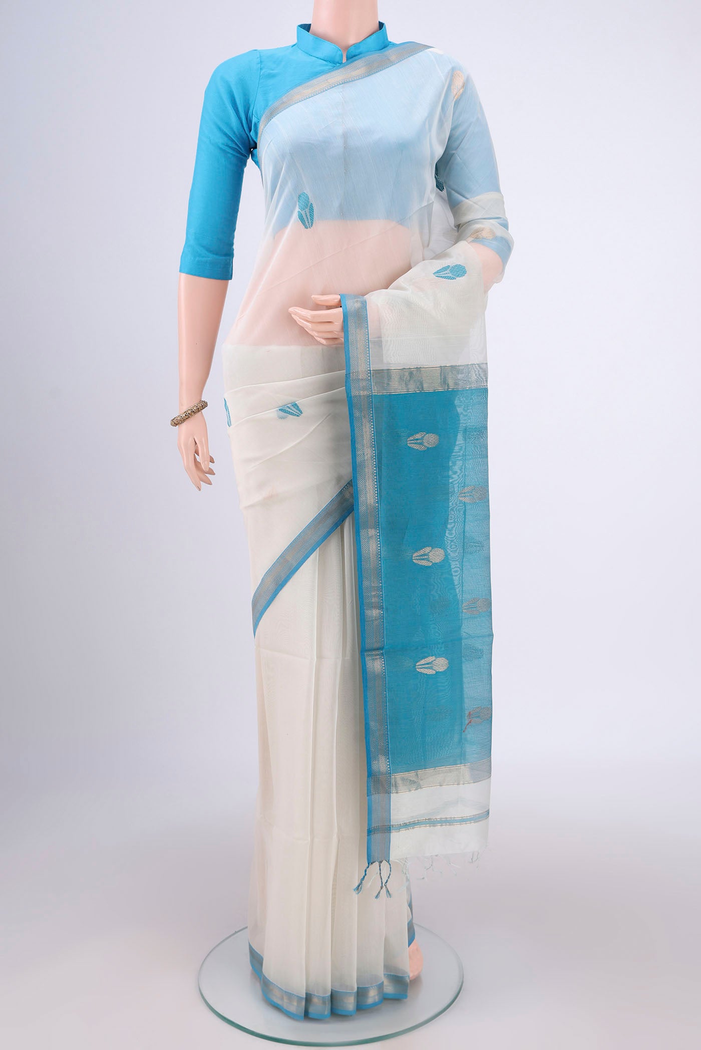 Off White Maheshwari Silk Cotton Saree with Zari And Thread Butta on the body and Zari Border.  displayed on a mannequin