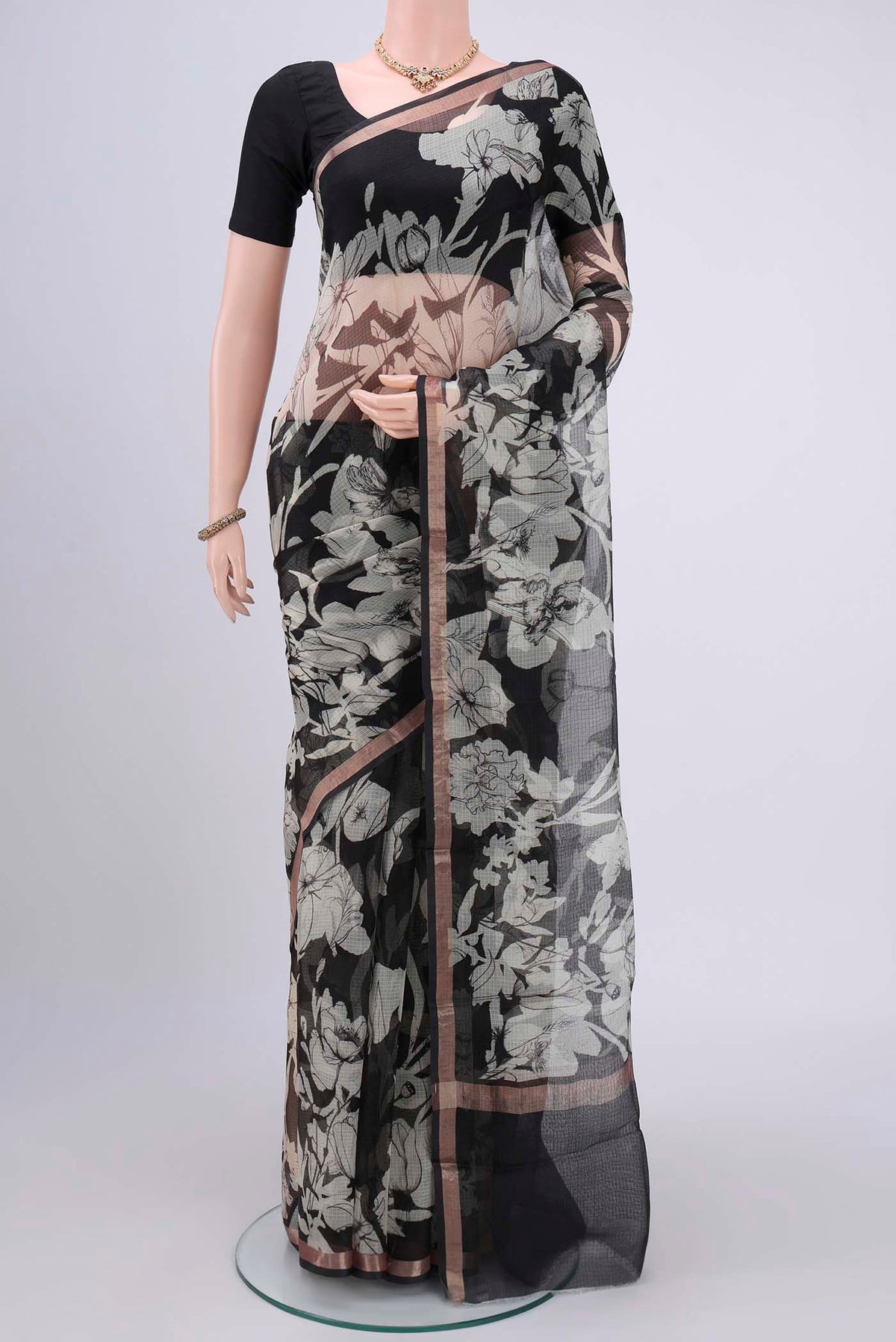 Black Kota Silk Saree with Printed design on the body and Zari Border.  displayed on a mannequin