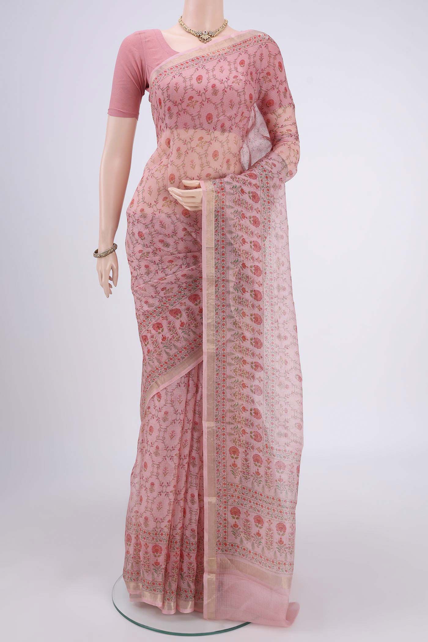 Peach Kota Silk Saree with Printed design on the body and Zari Border.  displayed on a mannequin