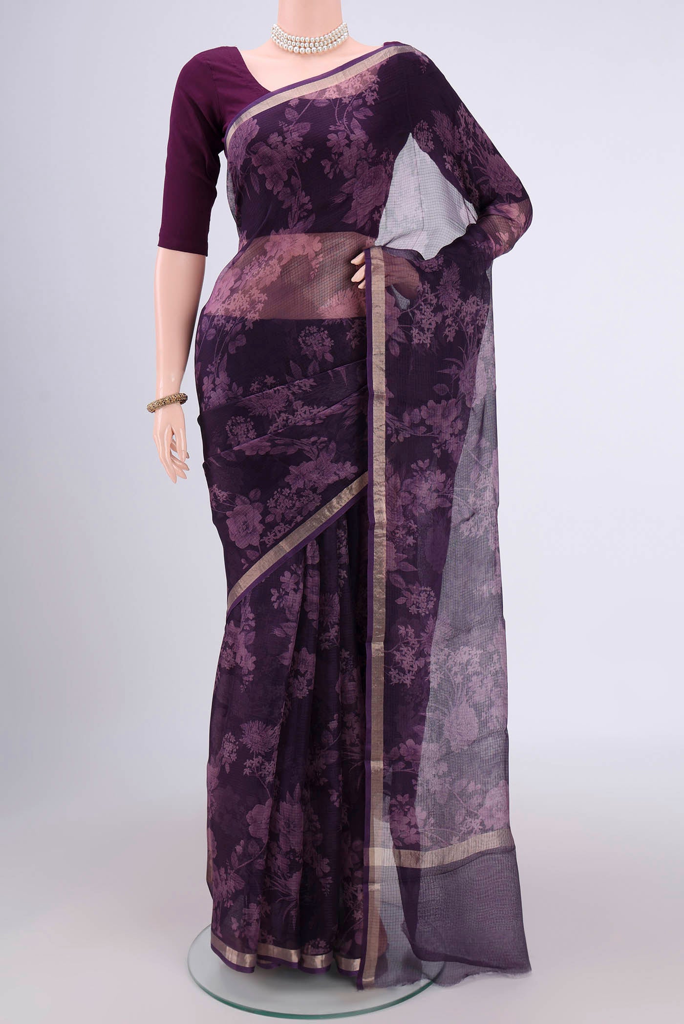 Purple Kota Silk Saree with Floral Print on the body and Zari Border.  displayed on a mannequin
