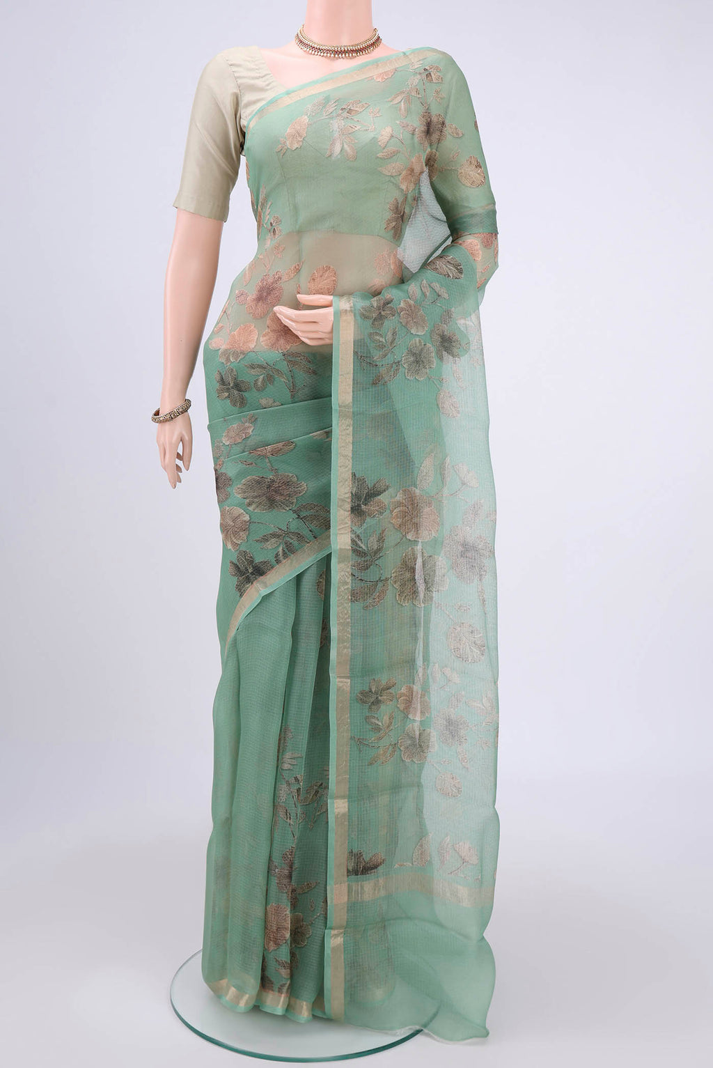 Sage Green Kota Silk Saree with Printed design on the body and Zari Border.  displayed on a mannequin