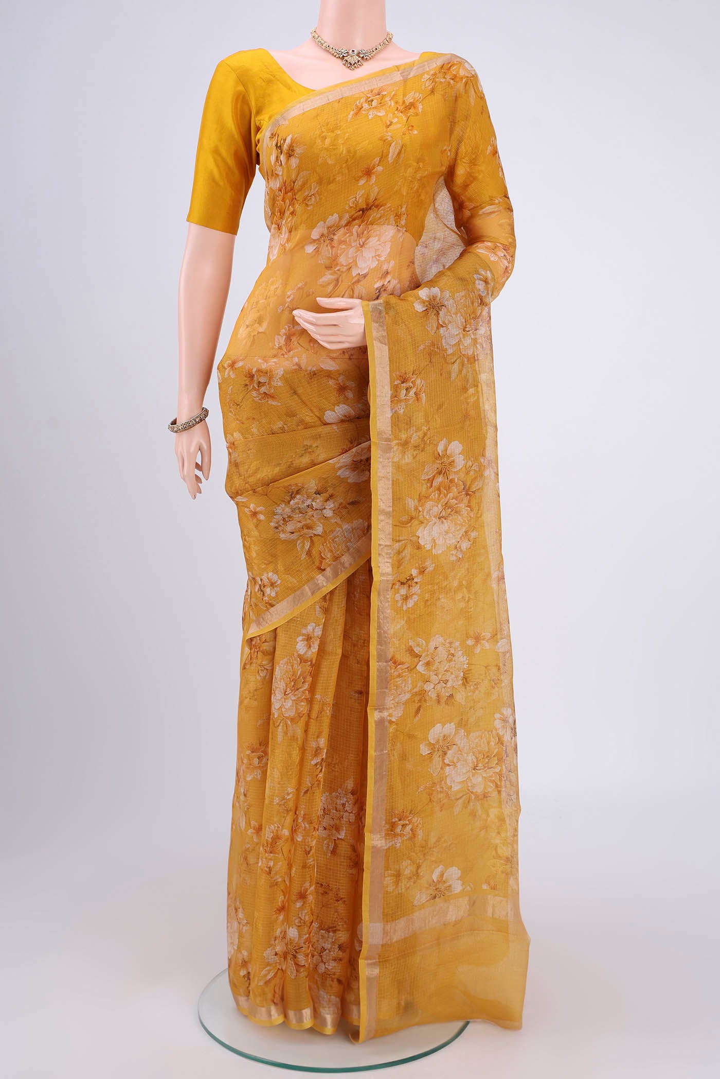 Mustard Kota Silk Saree with Printed design on the body and Zari Border.  displayed on a mannequin