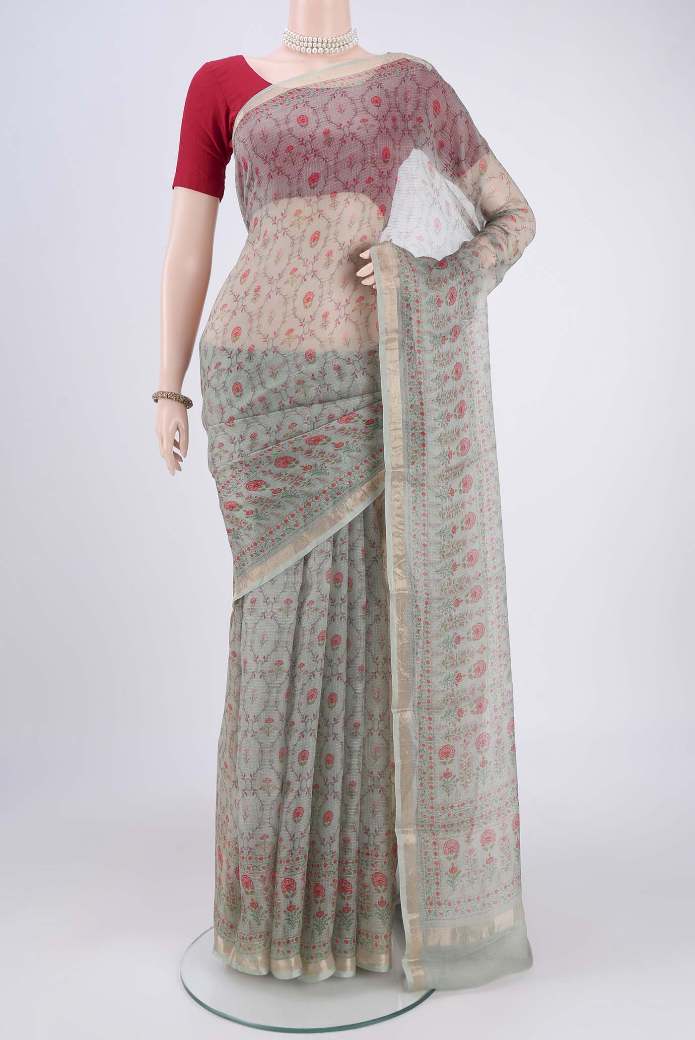 Sage Green Kota Silk Saree with Printed design on the body and Zari Border.  displayed on a mannequin