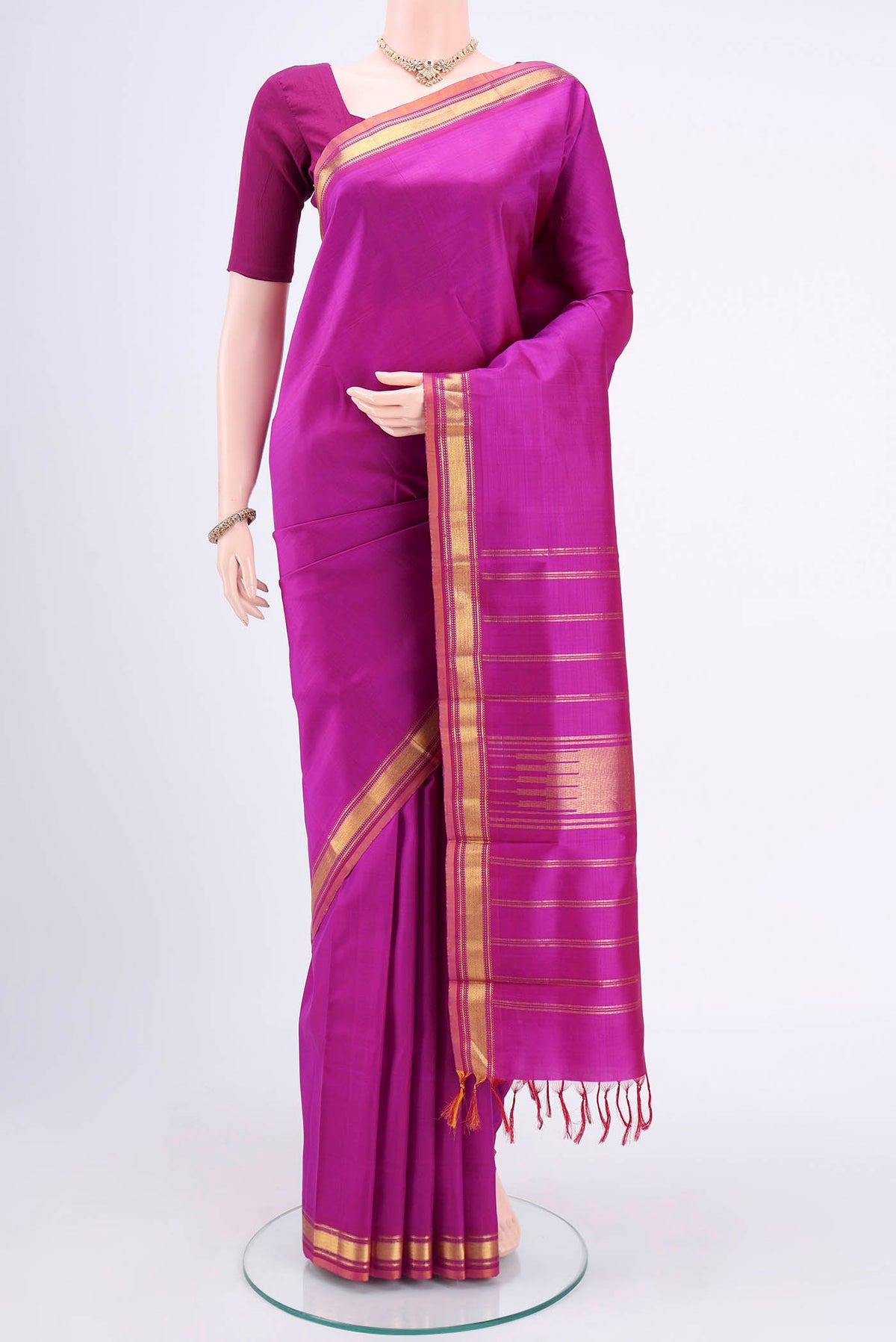 Magenta Kanjivaram Silk Saree with Plain Body and Zari Border.  displayed on a mannequin