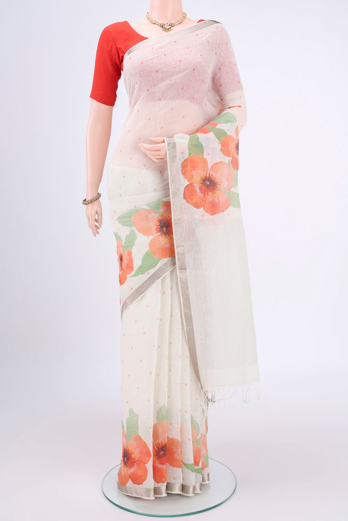 White Linen Saree with Floral Print on the body and Zari Border.  displayed on a mannequin