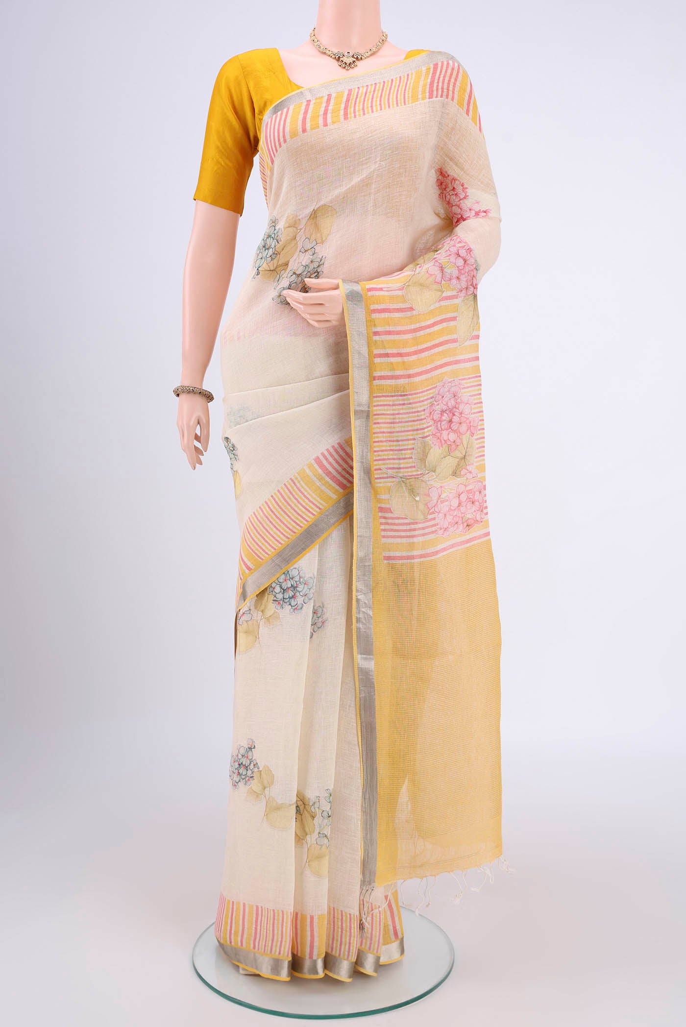 Beige Linen Saree with Floral Print on the body and Zari Border.  displayed on a mannequin