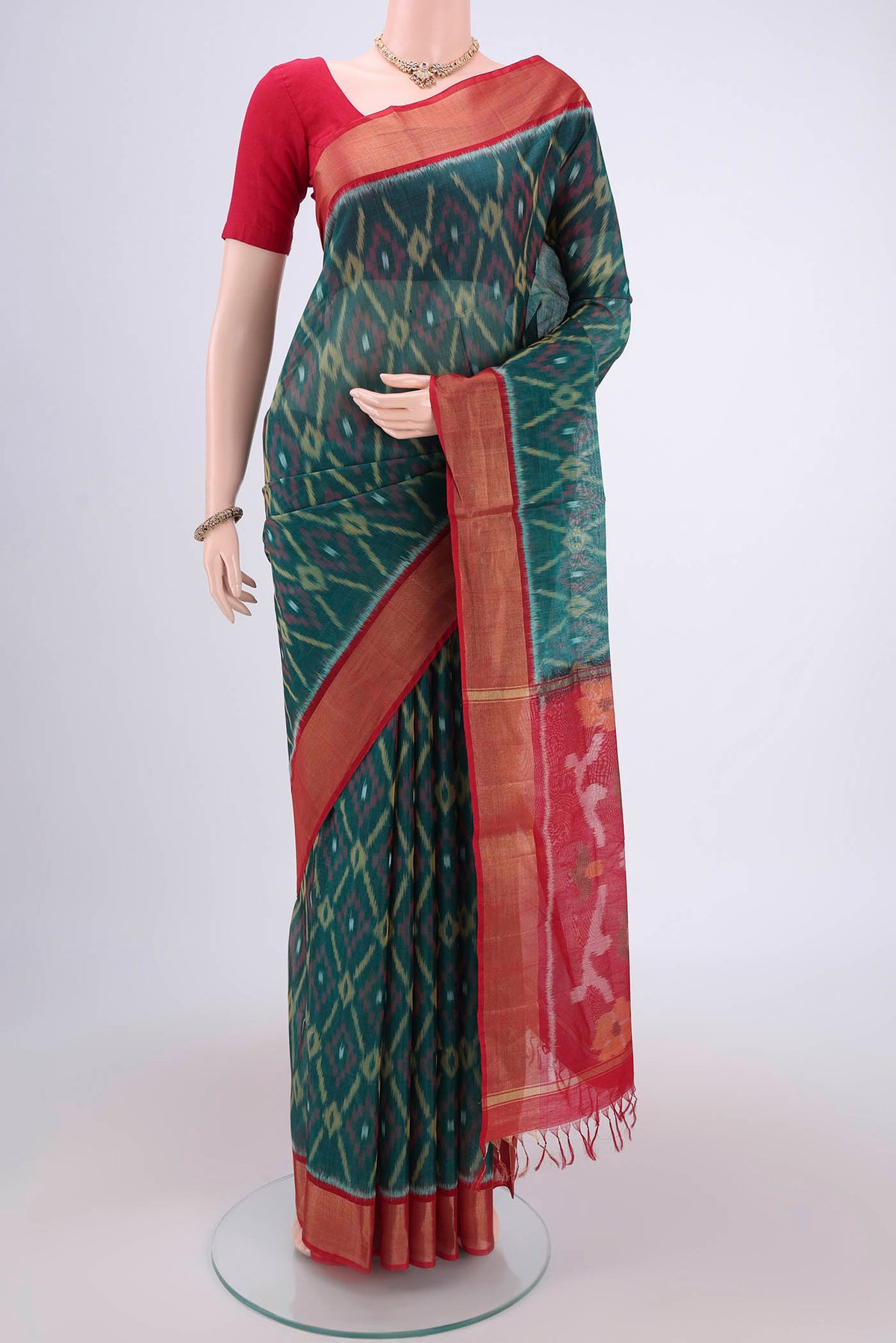Green Silk Cotton Saree with Ikat design on the body and Zari Border.  displayed on a mannequin