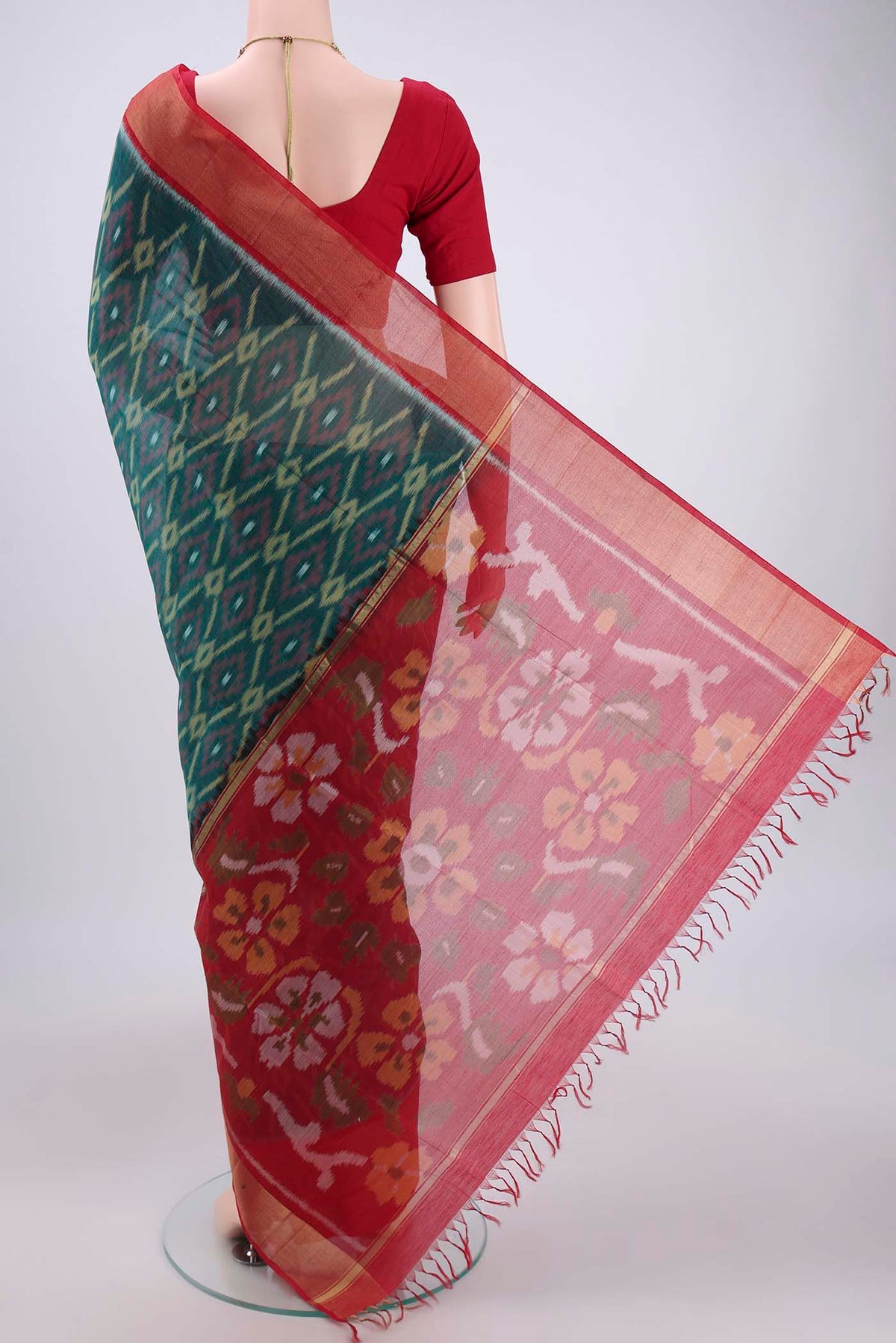 Flat view of Green Silk Cotton Saree with Ikat design on the body and Zari Border. 