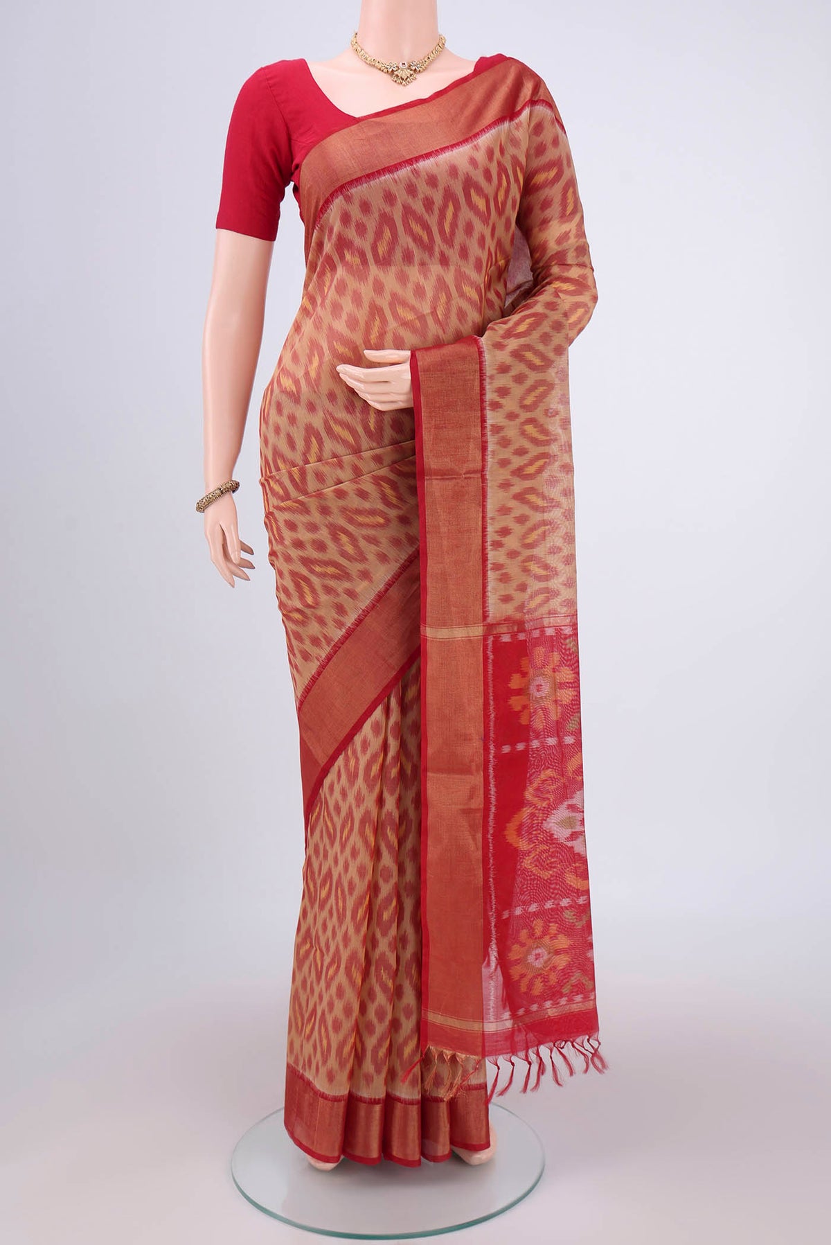 Dark Beige Silk Cotton Saree with Ikat design on the body and Zari Border.  displayed on a mannequin