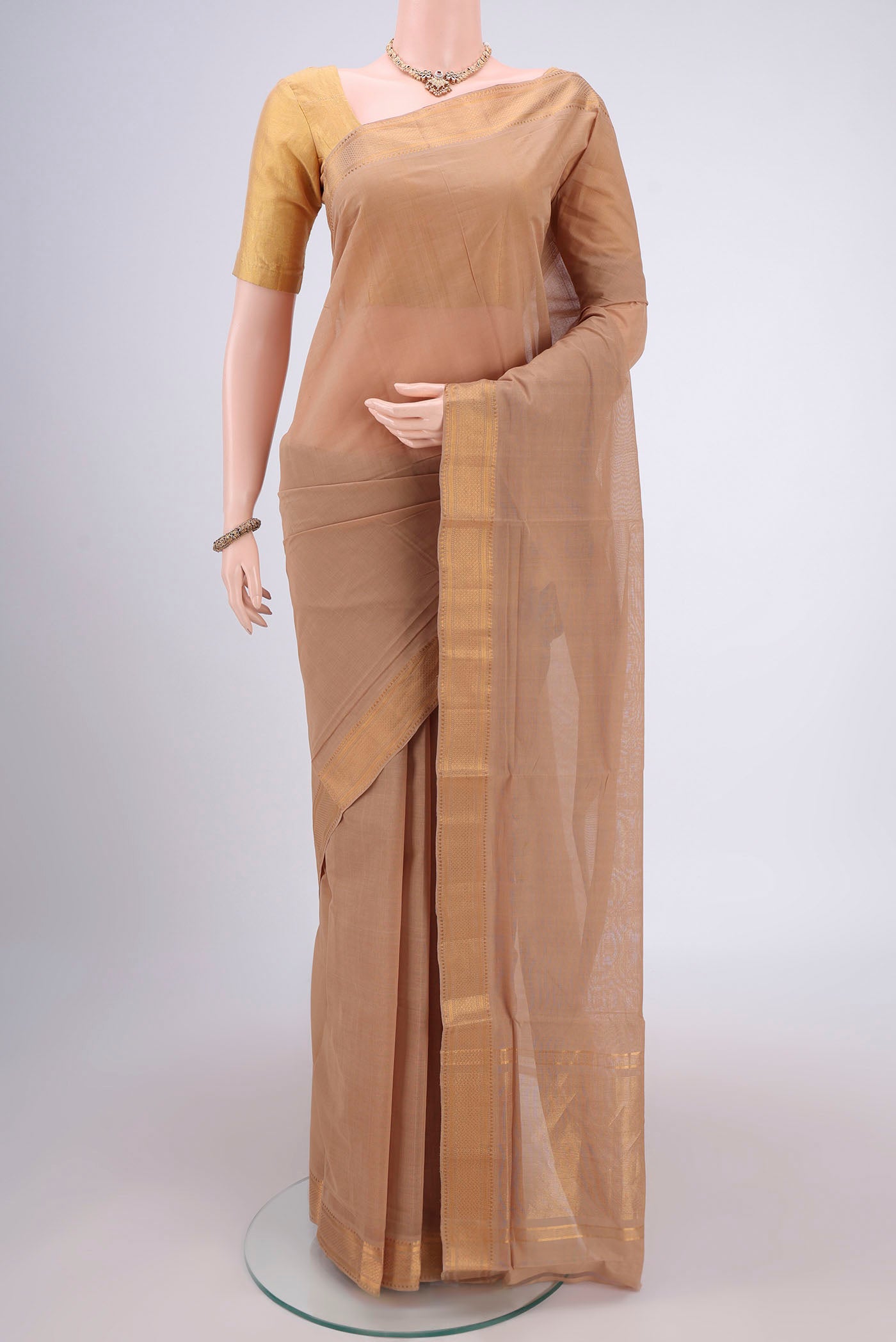 Beige Mangalagiri Cotton Saree with Plain Body and Zari Border.  displayed on a mannequin