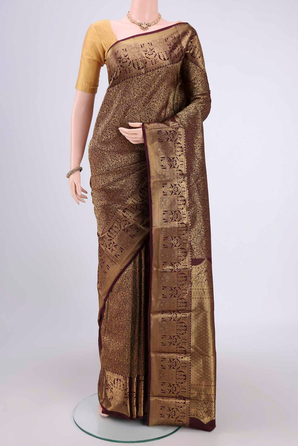 Brown Soft Silk Saree with Zari Butta on the body and Zari Border.  displayed on a mannequin
