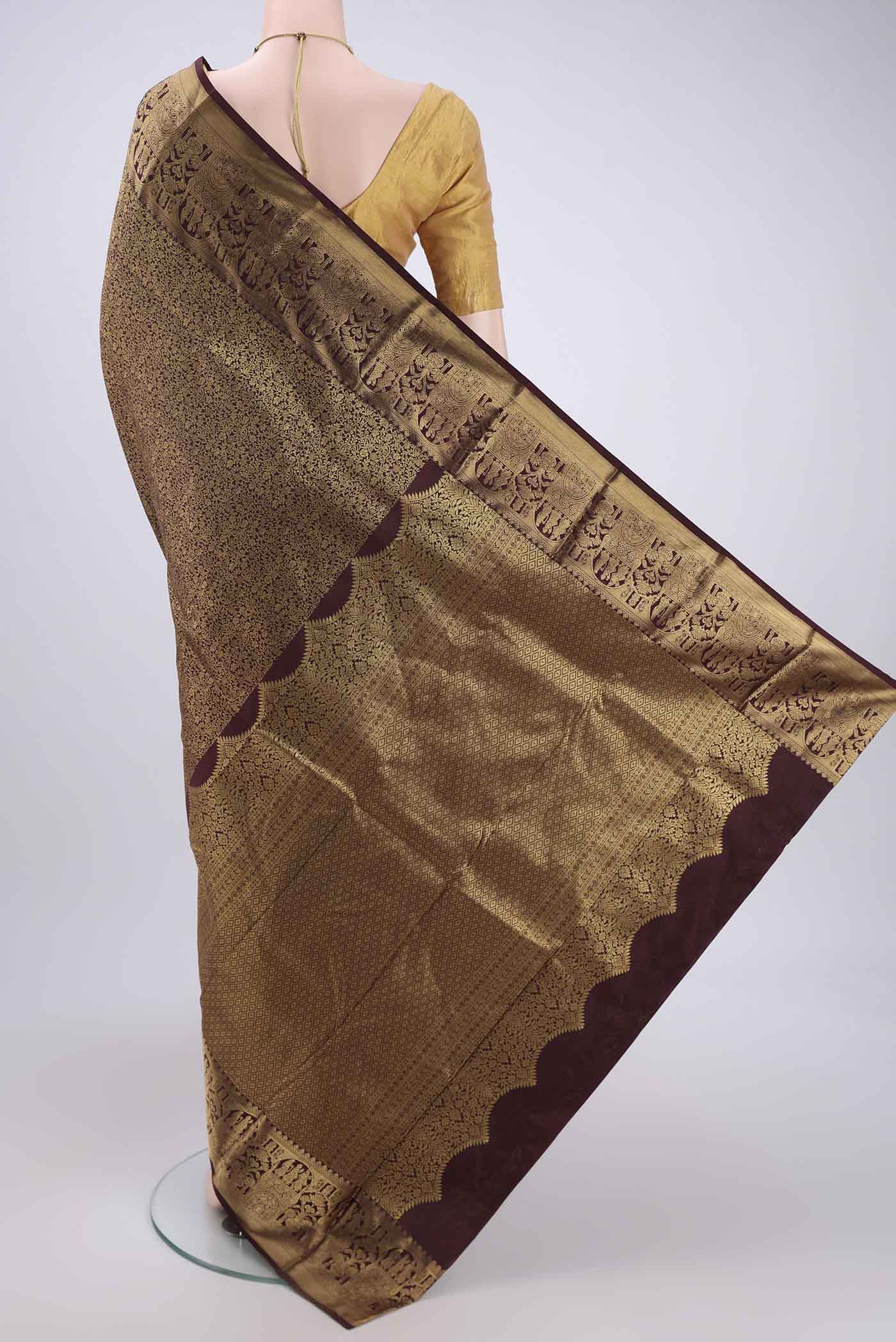 Flat view of Brown Soft Silk Saree with Zari Butta on the body and Zari Border. 