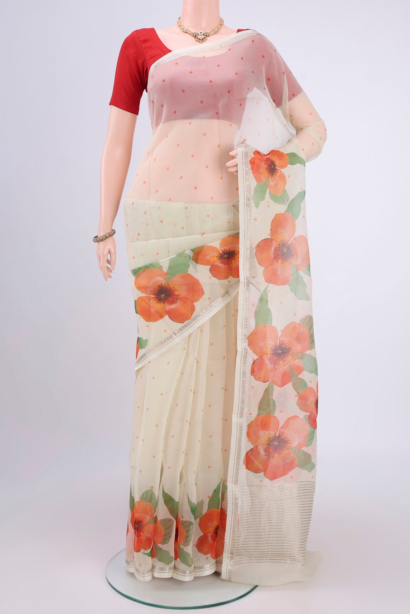 Off White Organza Silk Saree with Printed design on the body and Zari Border.  displayed on a mannequin
