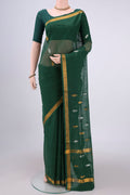 Green Cotton Saree with Zari Butta on the body and Zari Border.  displayed on a mannequin