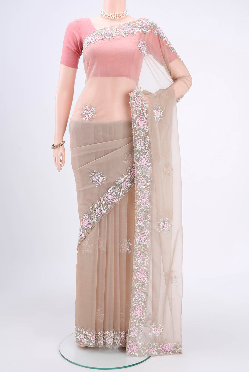Beige Organza Silk Saree with Embroidery on the body and Embroidery Border.  displayed on a mannequin
