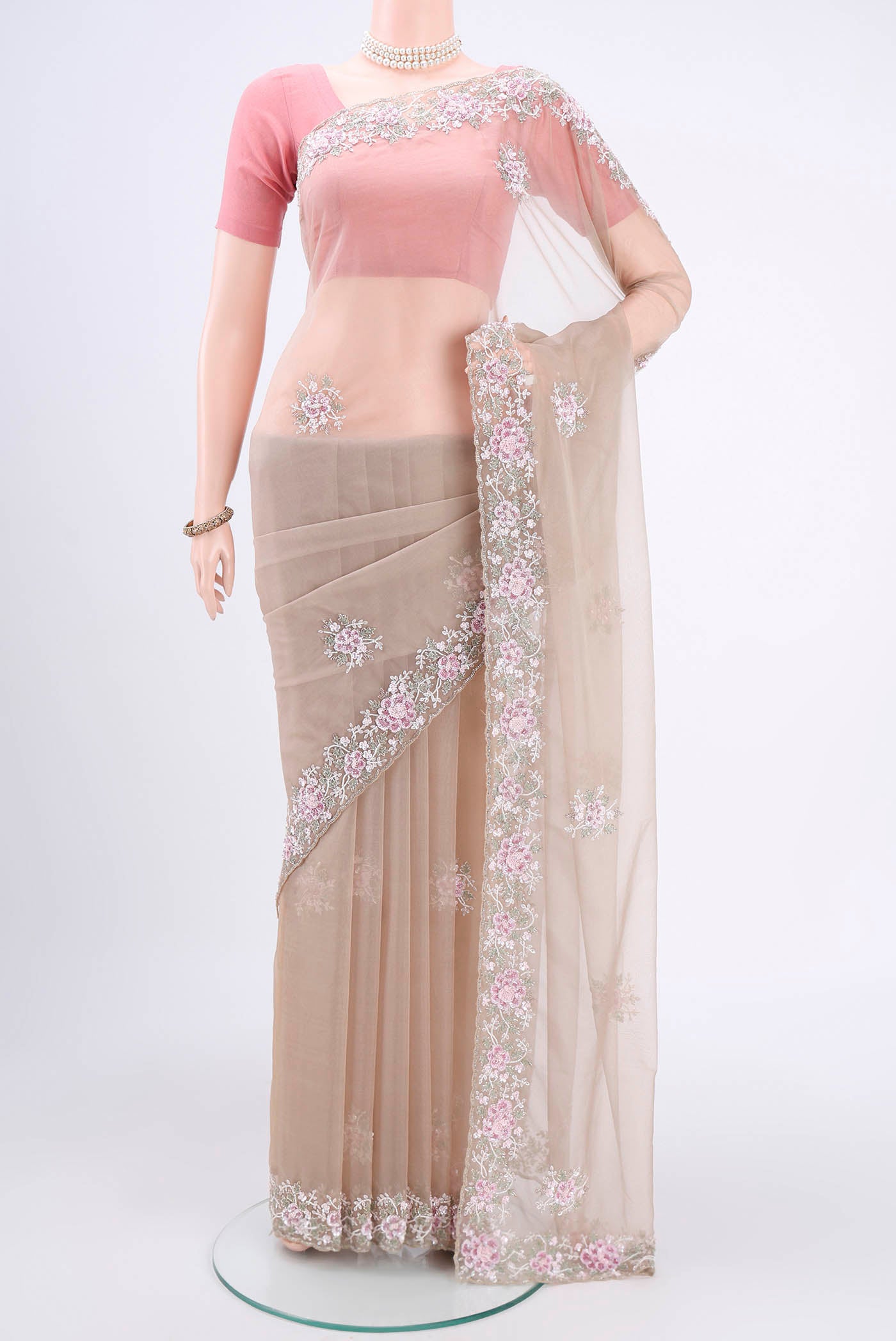 Beige Organza Silk Saree with Embroidery on the body and Embroidery Border.  displayed on a mannequin