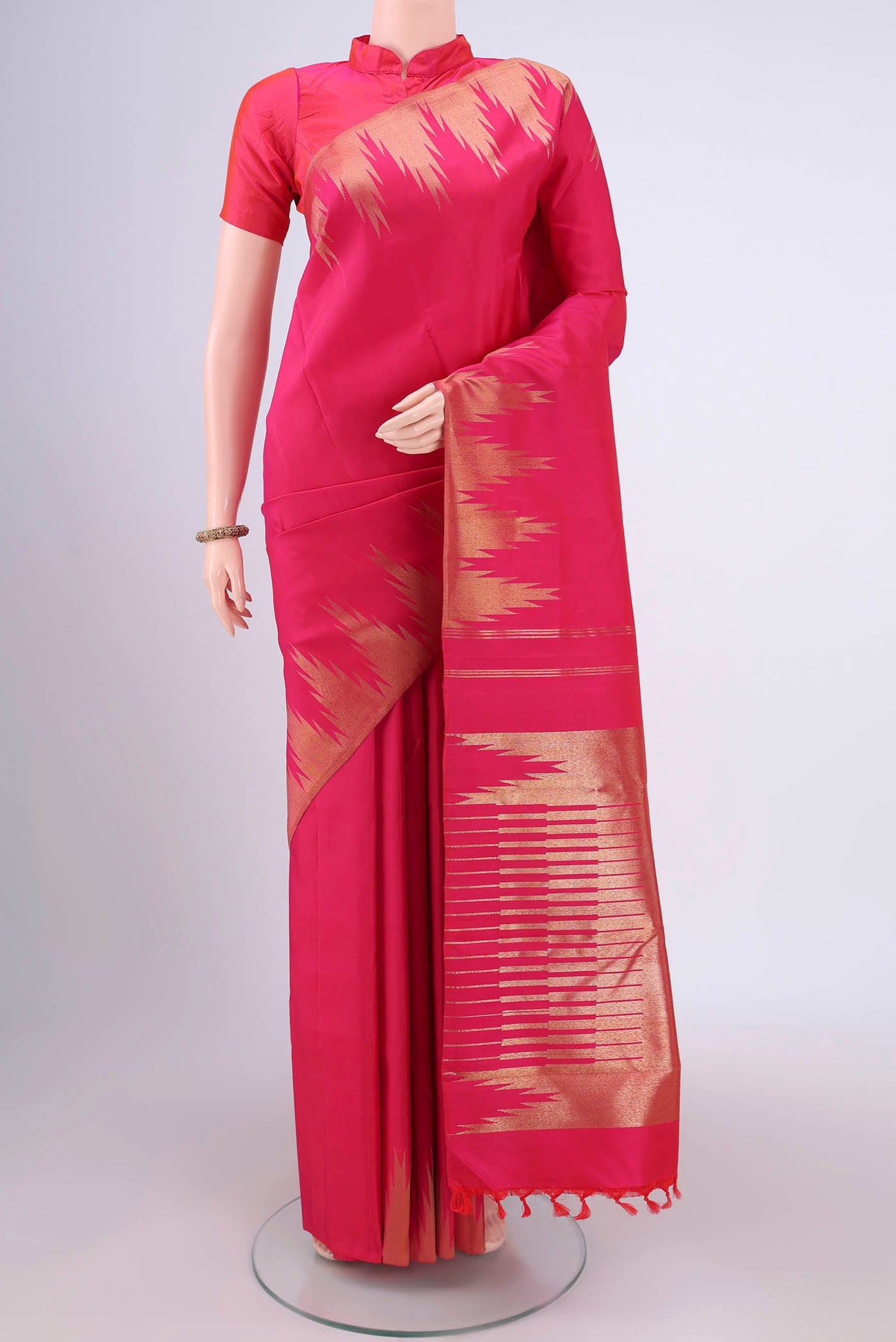 Pure Silk Pure Zari Rani Pink Kanchipuram Saree with Plain Body and Temple Border.  displayed on a mannequin