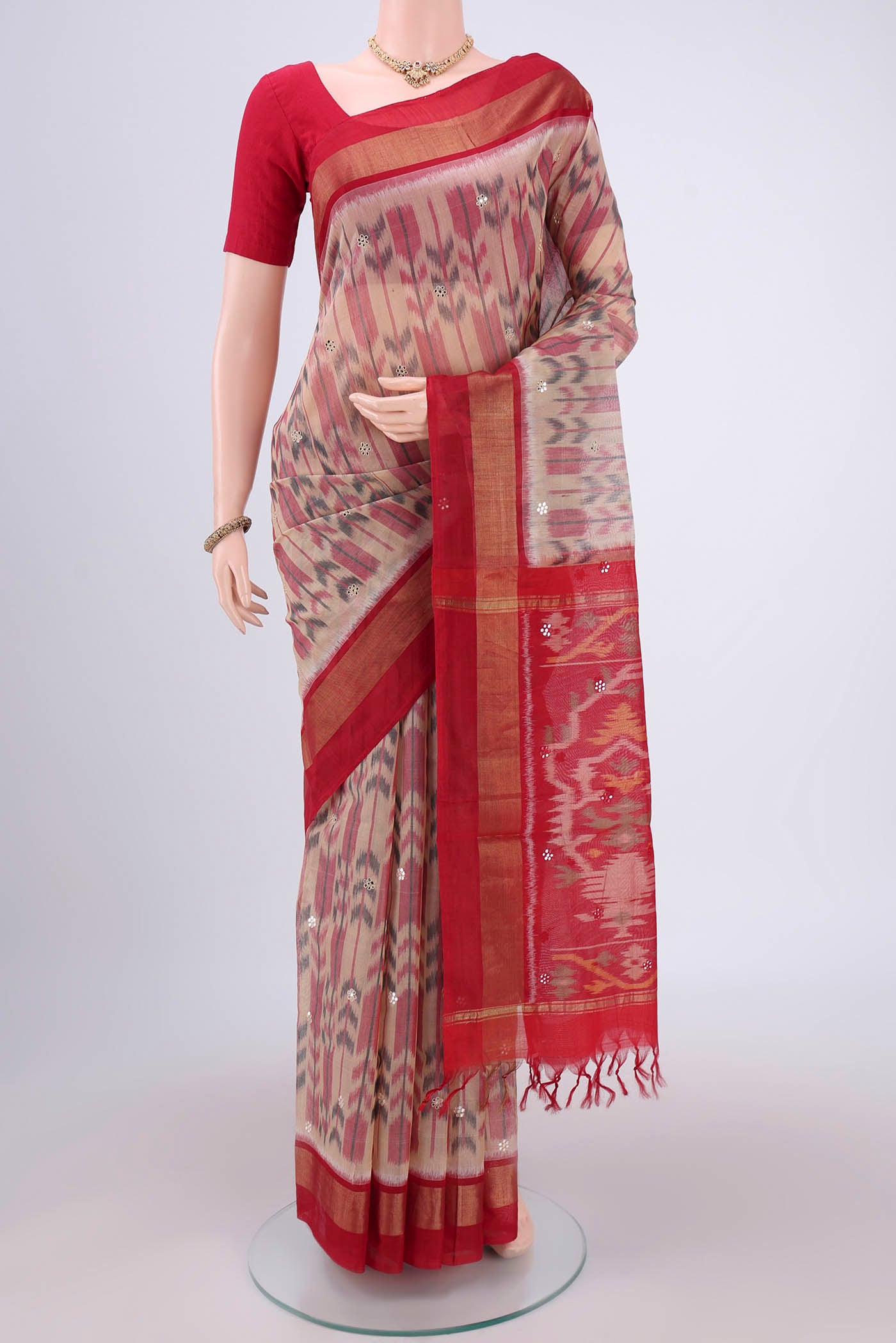 Peach Silk Cotton Saree with Ikat design on the body and Zari Border.  displayed on a mannequin