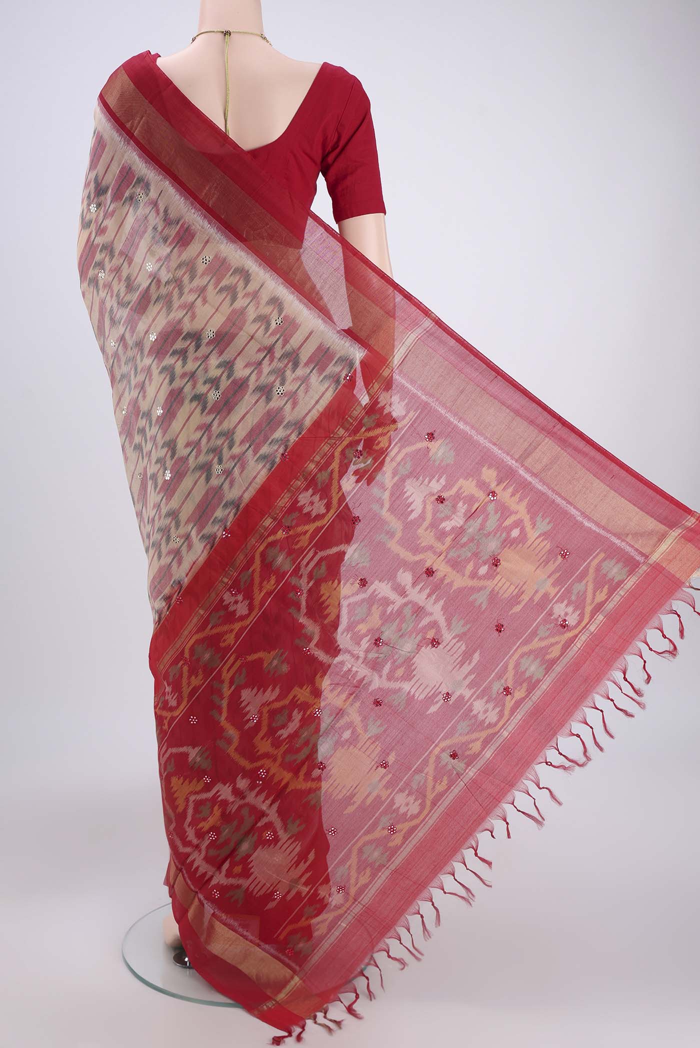 Flat view of Peach Silk Cotton Saree with Ikat design on the body and Zari Border. 