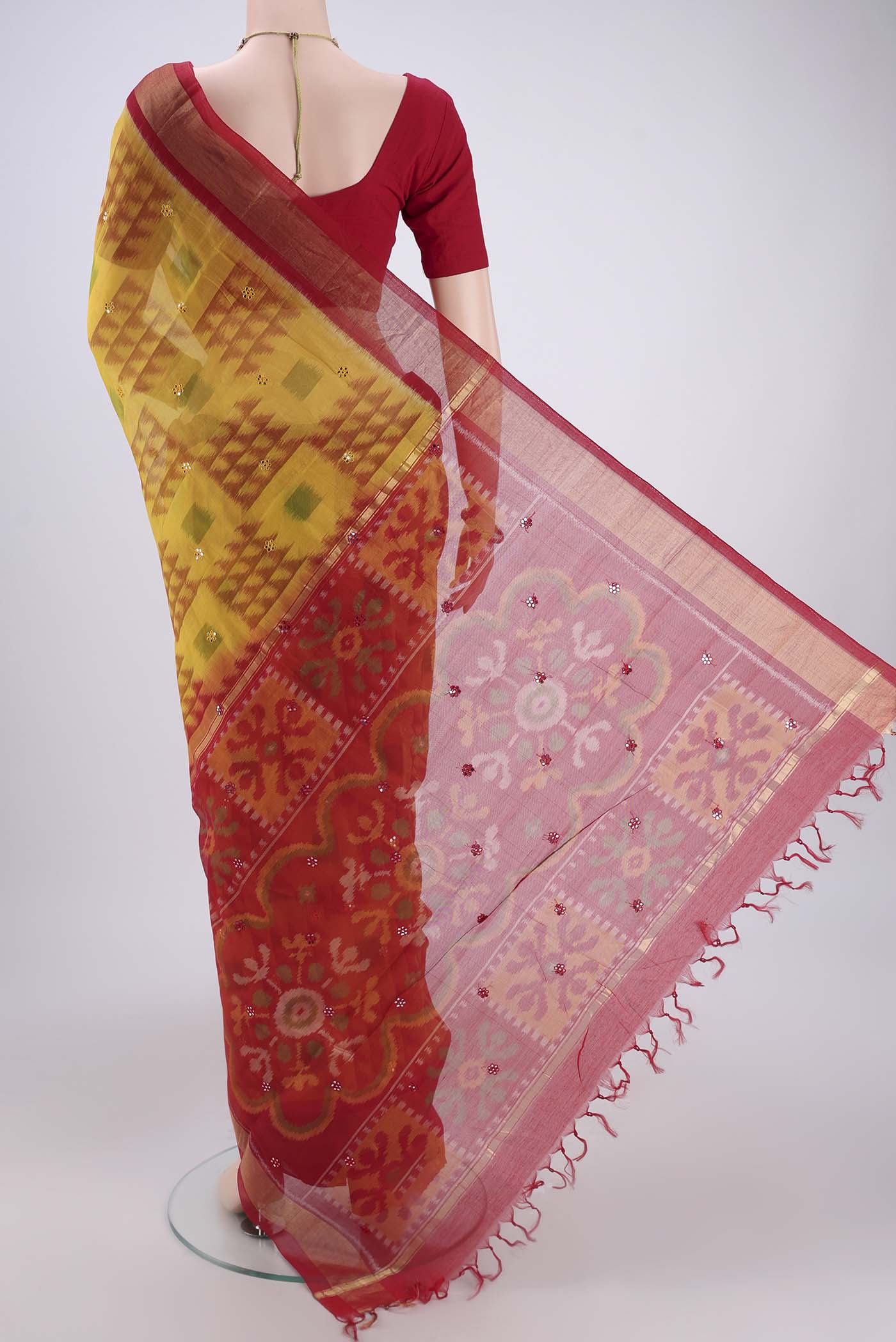 Flat view of Yellow Silk Cotton Saree with Ikat design on the body and Zari Border. 