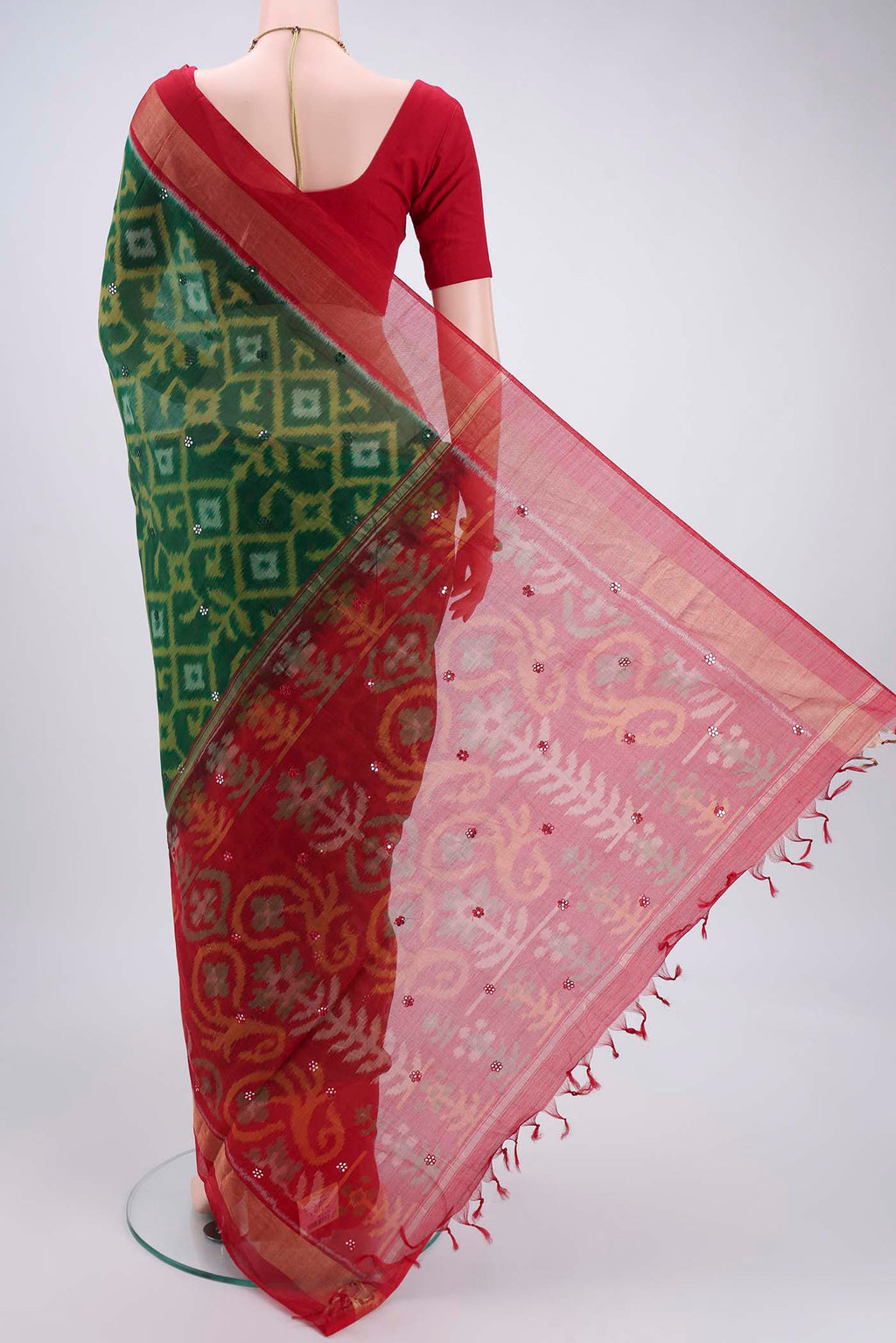 Flat view of Green Kora Cotton Saree with Ikat design on the body and Zari Border. 