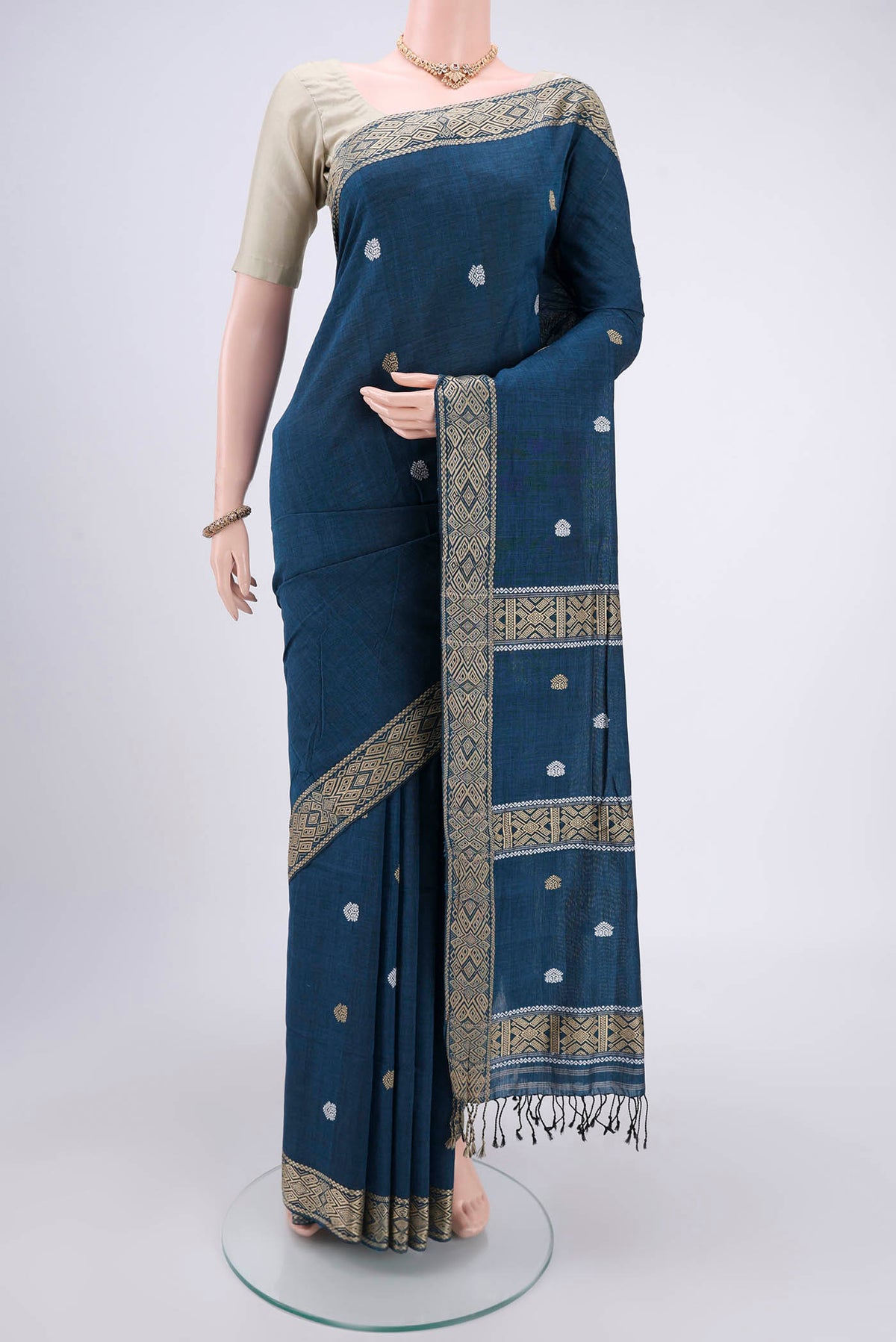 Turquoise Assam Cotton Saree with Thread Butta on the body and Plain Border.  displayed on a mannequin
