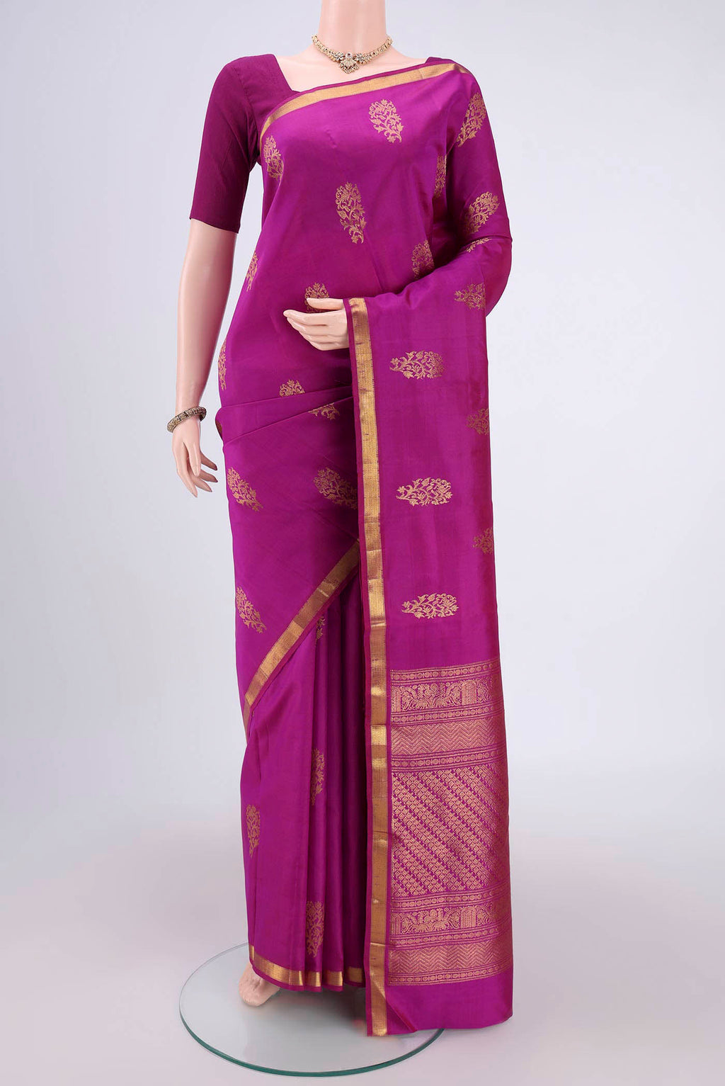 Magenta Kanchipuram Silk Saree with Zari Butta on the body and Zari Border.  displayed on a mannequin