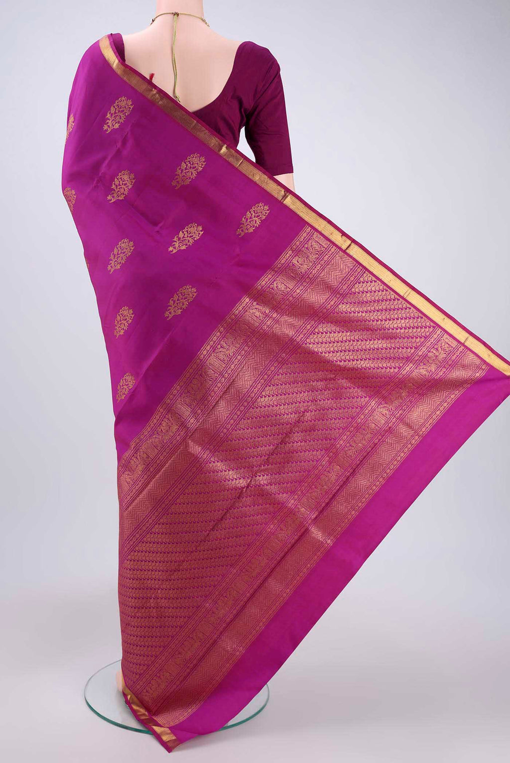 Flat view of Magenta Kanchipuram Silk Saree with Zari Butta on the body and Zari Border. 