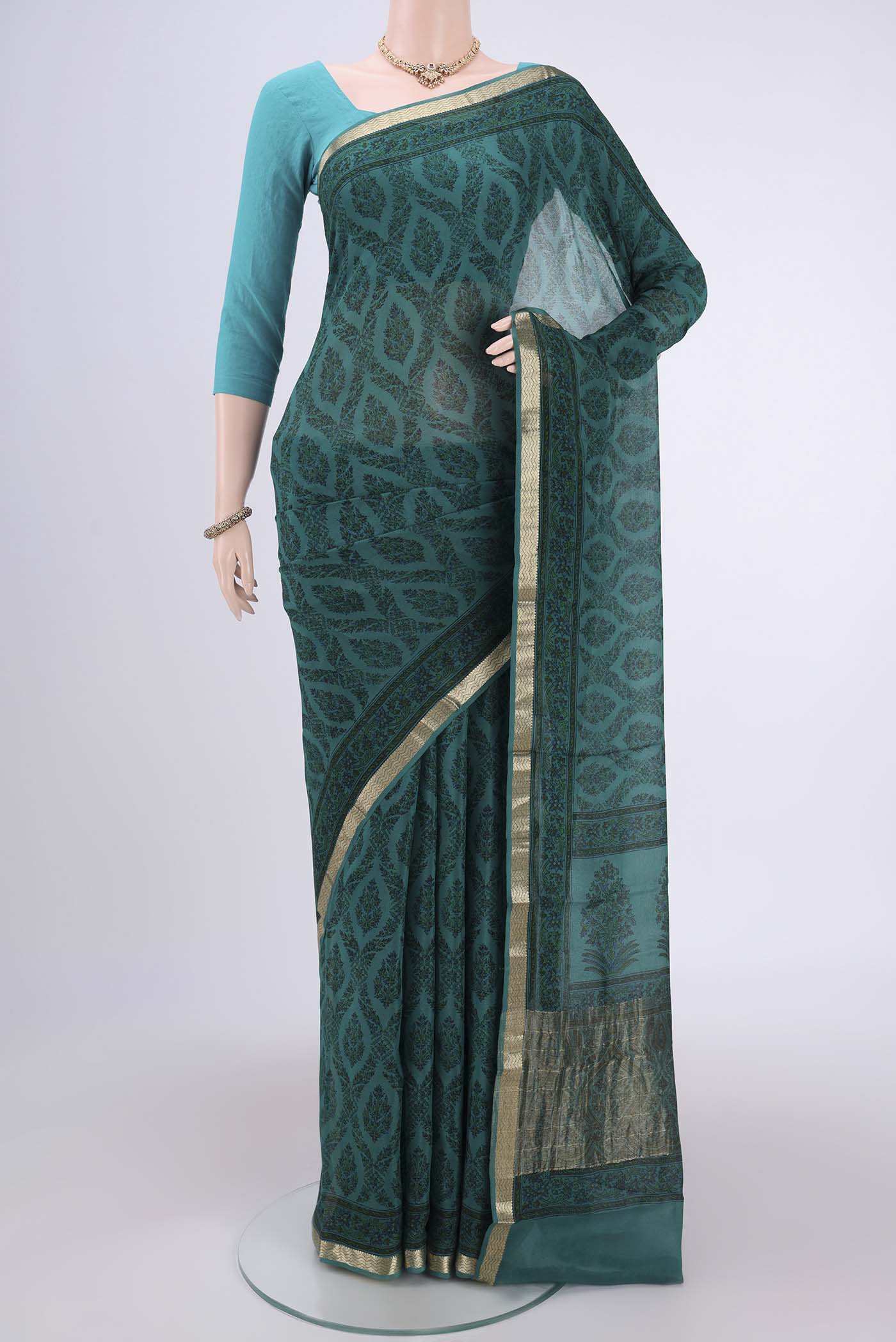 Turquoise Mysore Crepe Saree with Floral Print on the body and Zari Border.  displayed on a mannequin