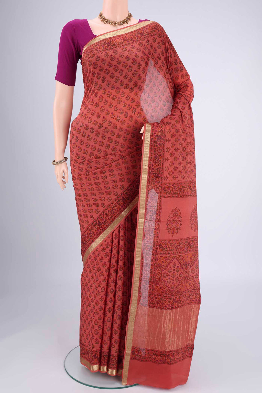 Coral Mysore Crepe Saree with Floral Print on the body and Zari Border.  displayed on a mannequin