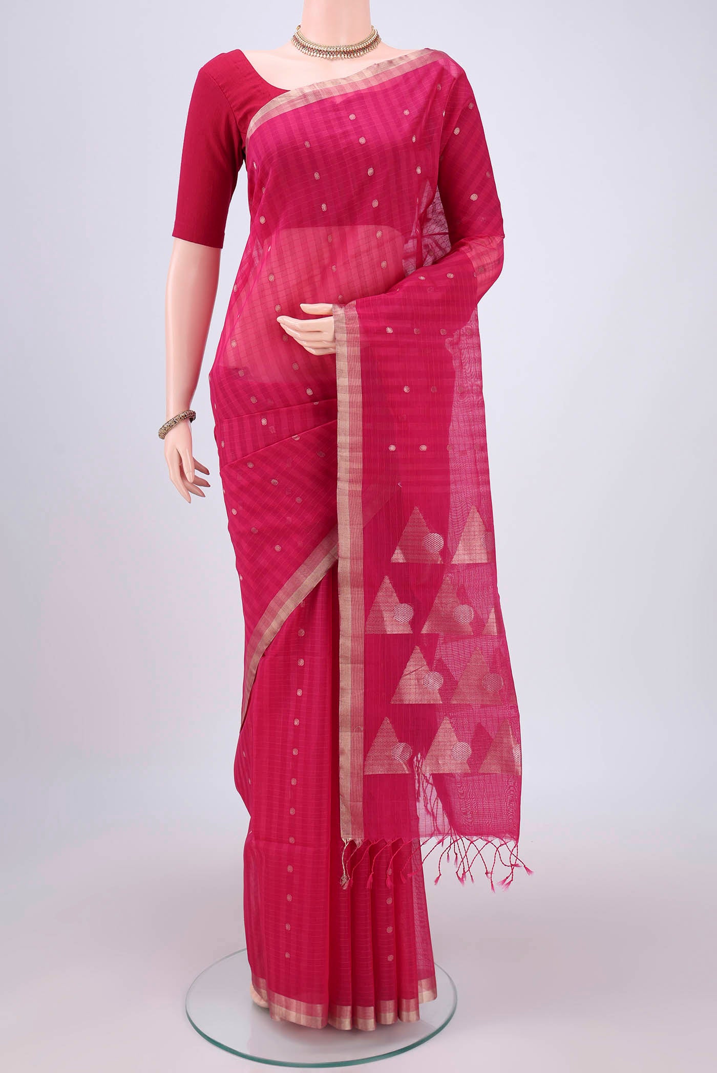 Rani Pink Silk Cotton Saree with Zari Butta on the body and Zari Border.  displayed on a mannequin