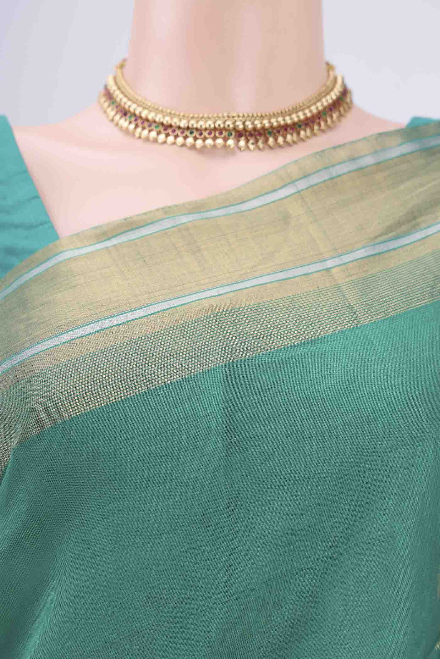 Border image of Sea Green Silk Cotton Saree with Zari Butta on the body and Zari Border. 