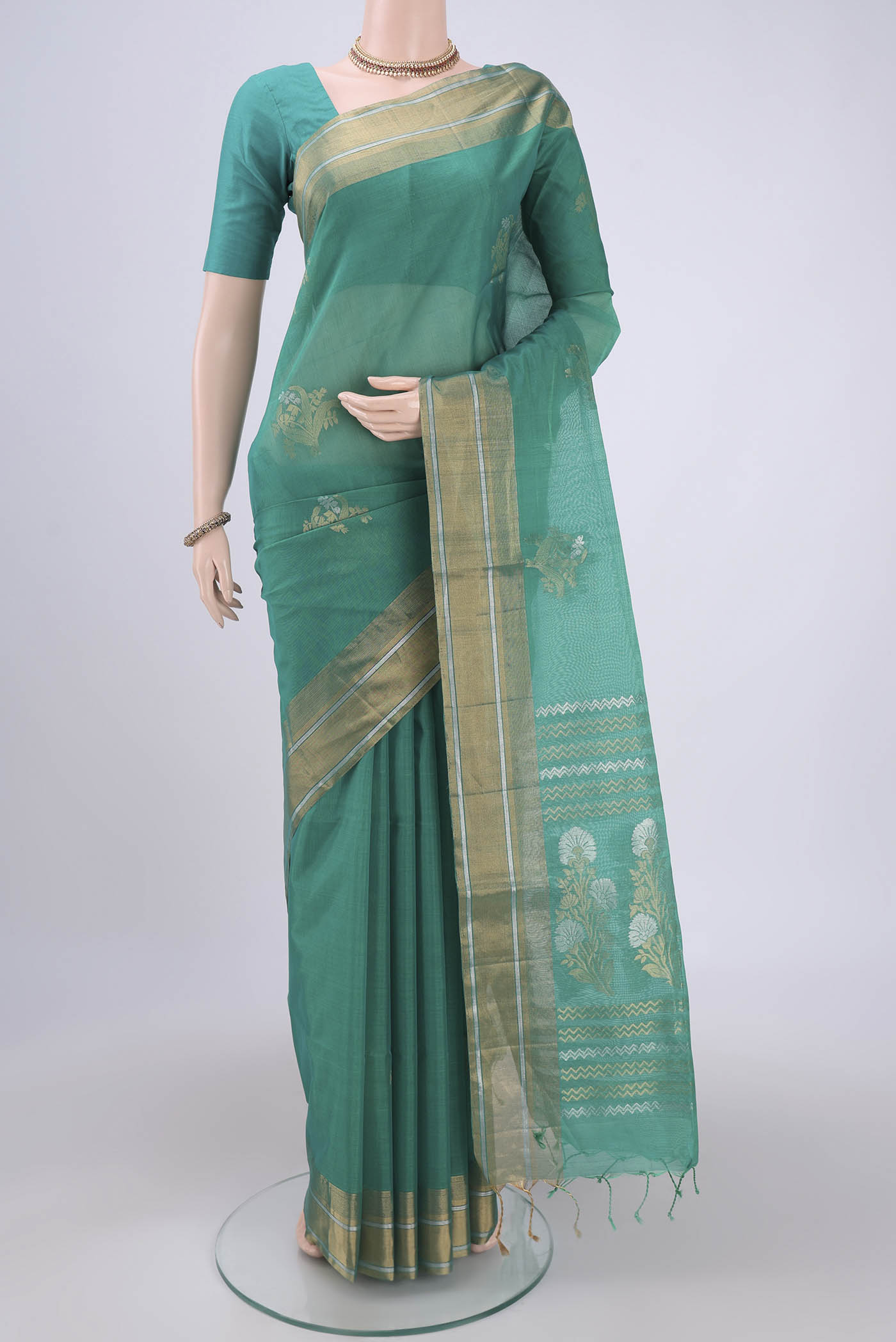 Sea Green Silk Cotton Saree with Zari Butta on the body and Zari Border.  displayed on a mannequin