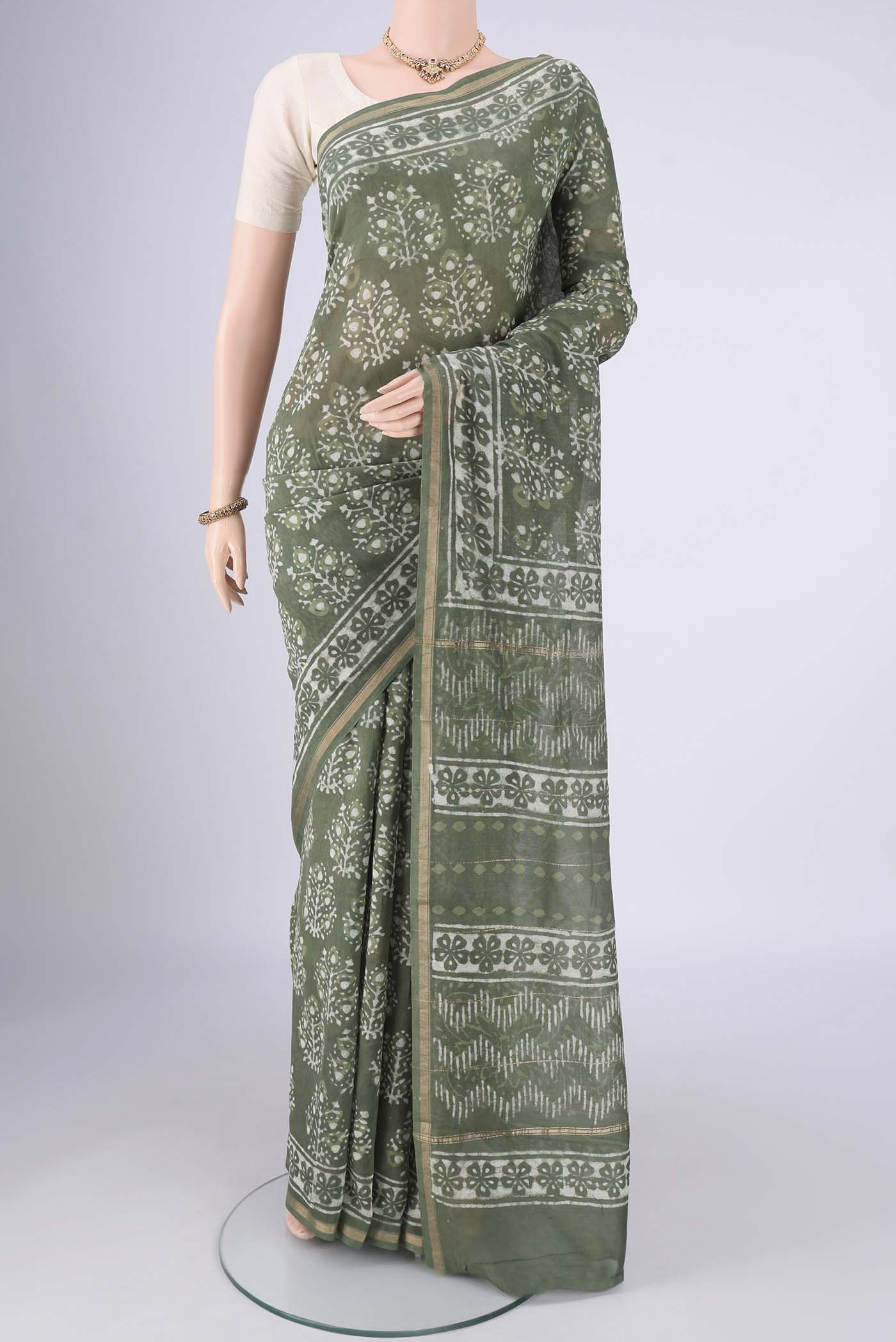 Sea Green Maheshwari Silk Cotton Saree with Batik Print on the body and Zari Border.  displayed on a mannequin
