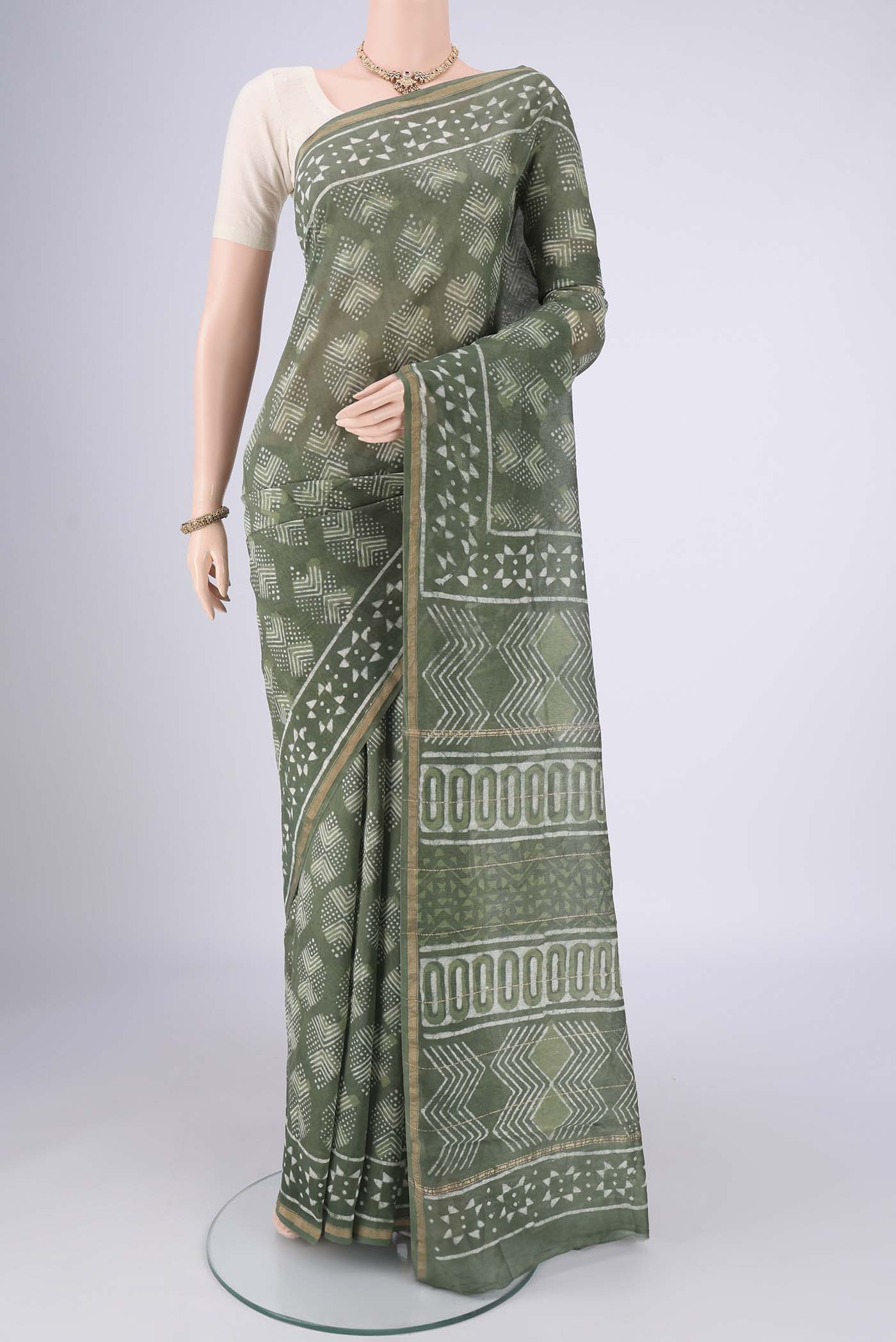 Mehandi Green Maheshwari Silk Cotton Saree with Batik Print on the body and Zari Border.  displayed on a mannequin