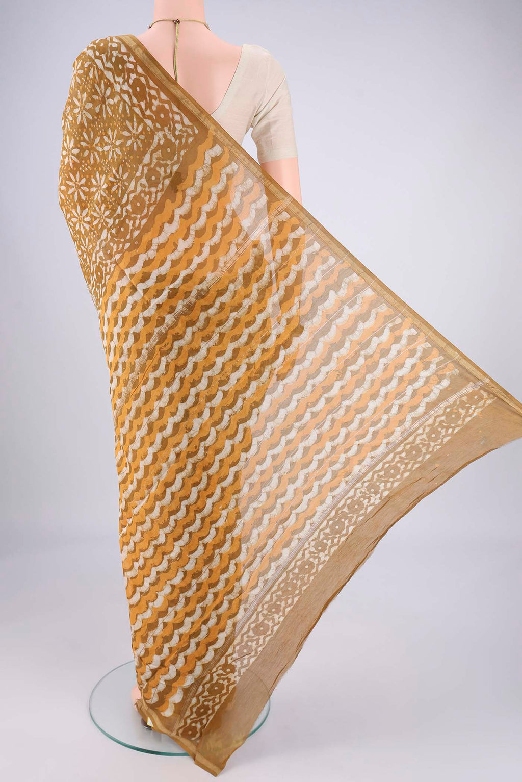 Flat view of Mustard Maheshwari Silk Cotton Saree with Batik Print on the body and Zari Border. 