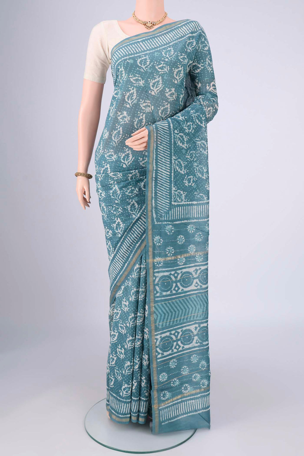 Maya Blue Maheshwari Silk Cotton Saree with Batik Print on the body and Zari Border.  displayed on a mannequin