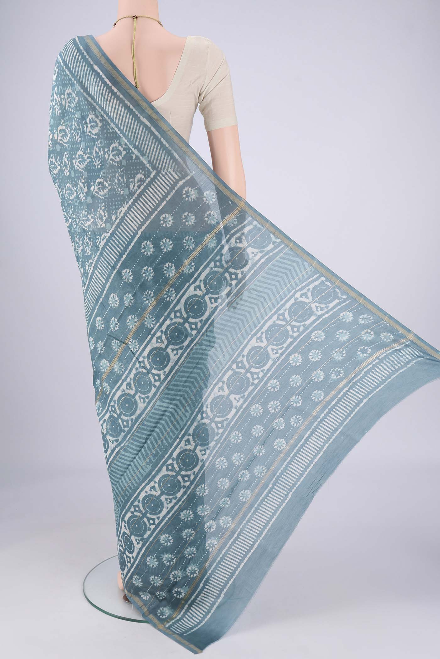 Flat view of Maya Blue Maheshwari Silk Cotton Saree with Batik Print on the body and Zari Border. 