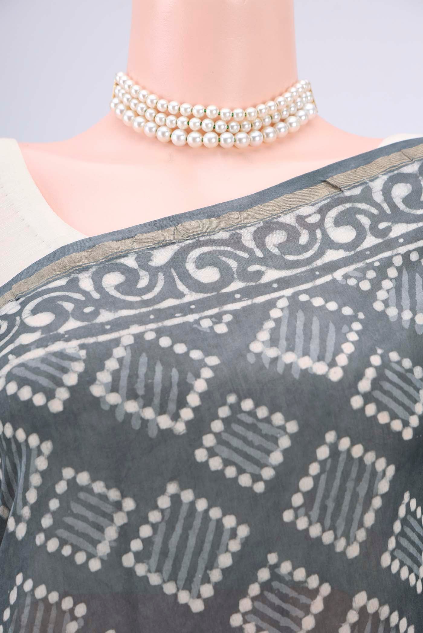 Border image of Grey Maheshwari Silk Cotton Saree with Batik Print on the body and Zari Border. 